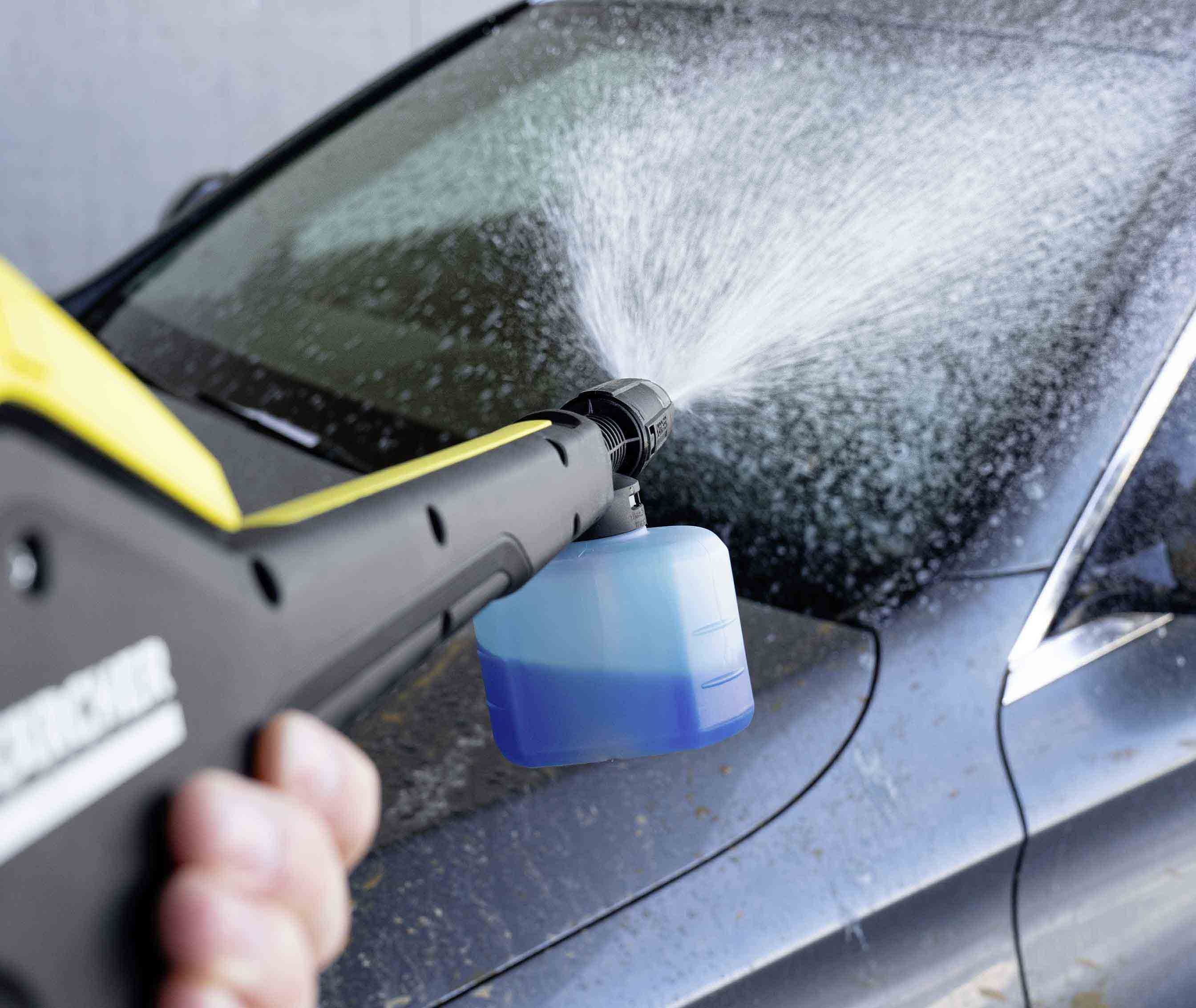 Una hidrolimpiadora rocía espuma sobre un coche.