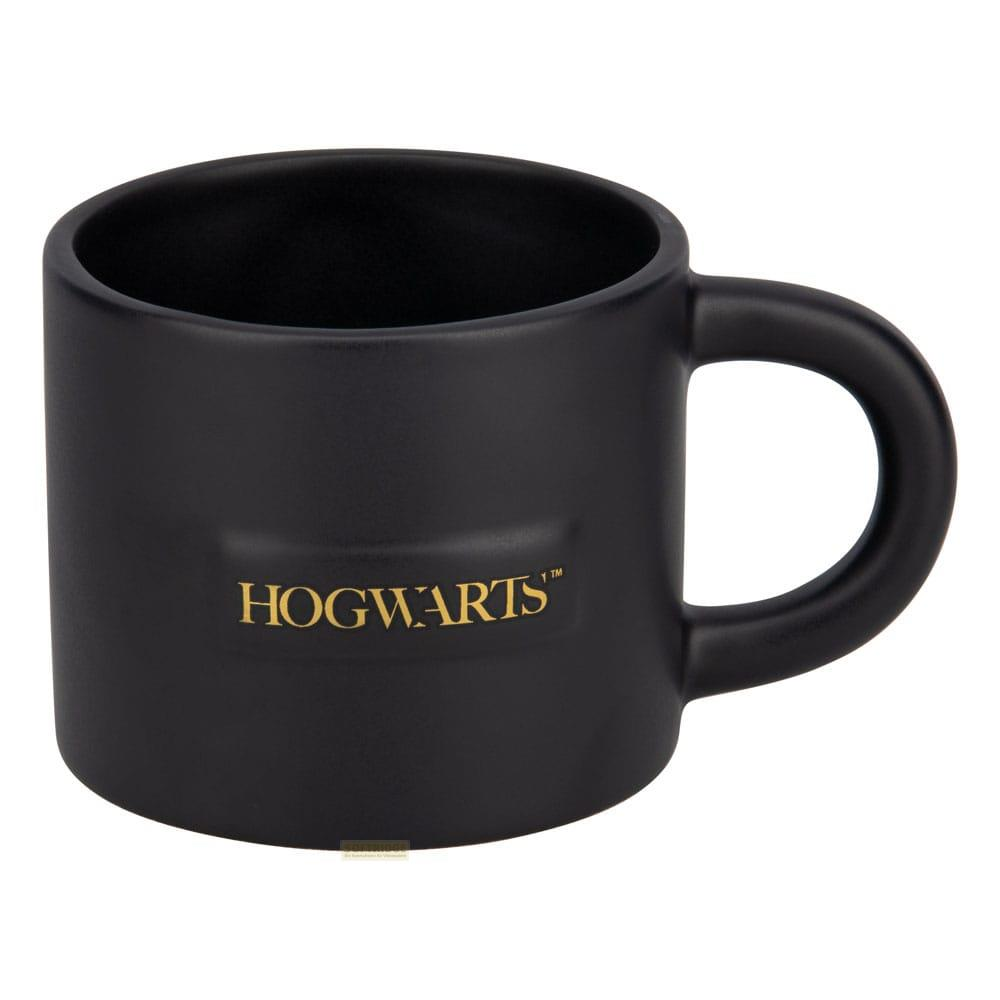 Czarny kubek ze złotym logo Hogwartu.