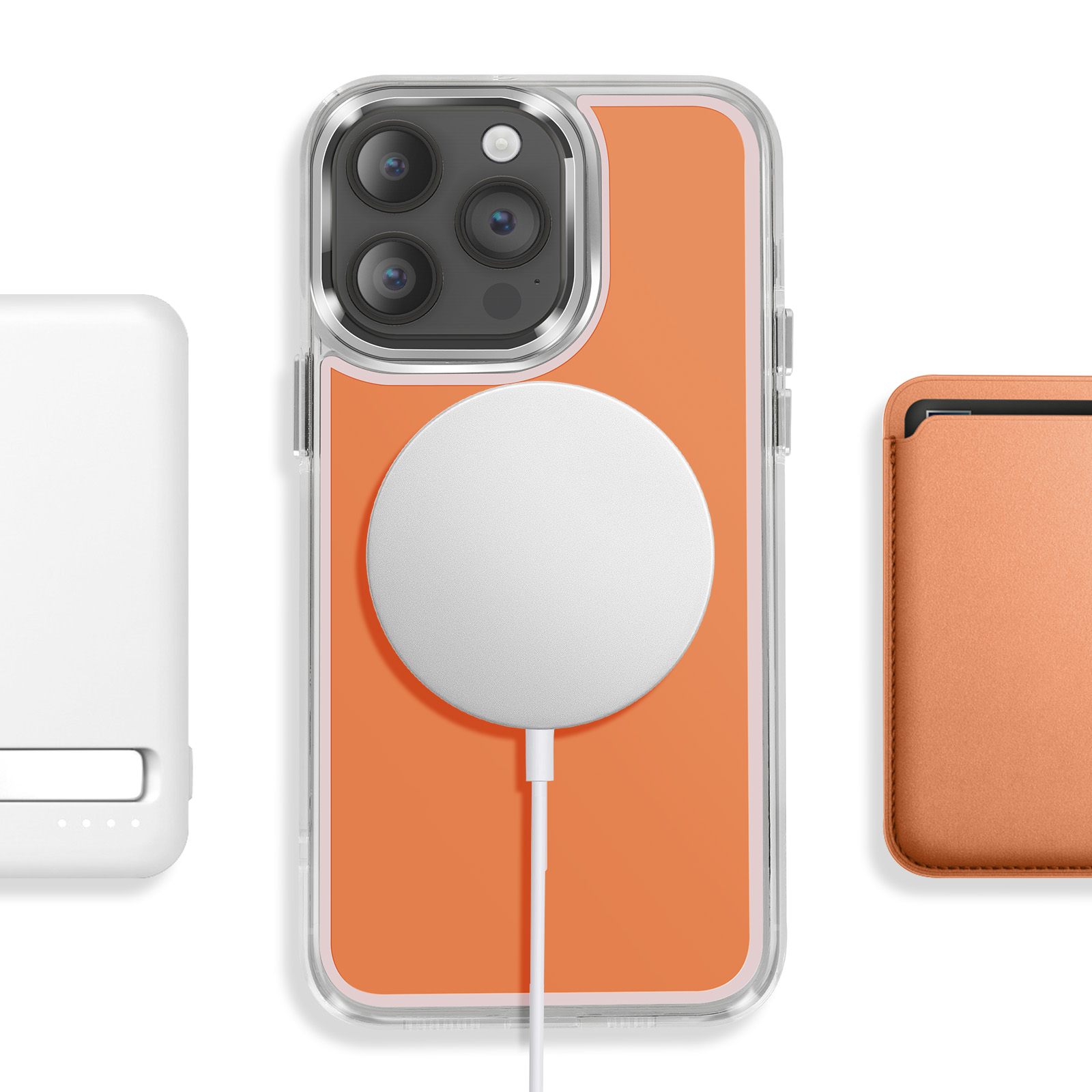 Een witte oplader, een oranje telefoon met hoesje en MagSafe-oplader, en een portemonnee.