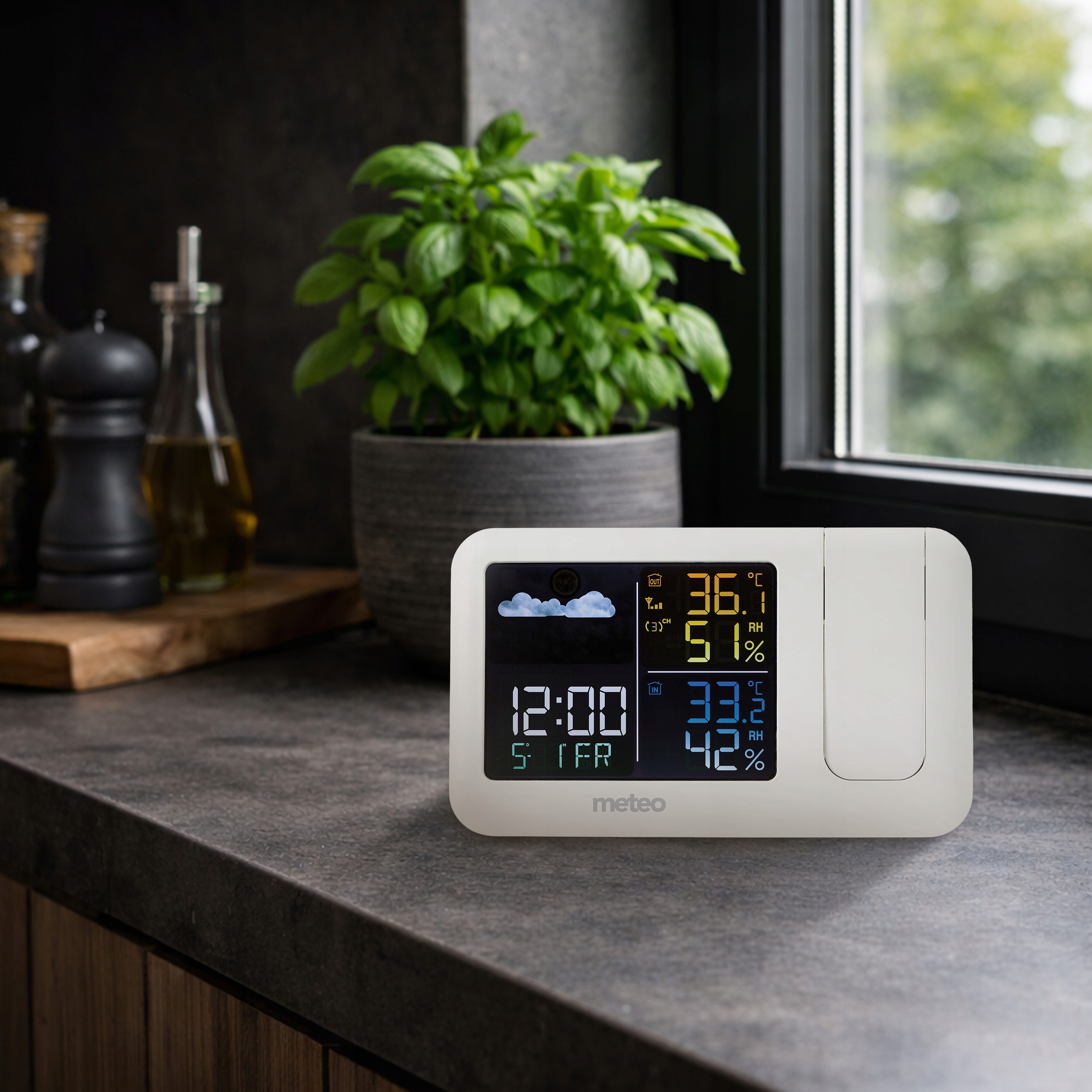 Wyświetlacz stacji pogodowej pokazuje czas, temperaturę zewnętrzną, wilgotność i prognozę pogody.