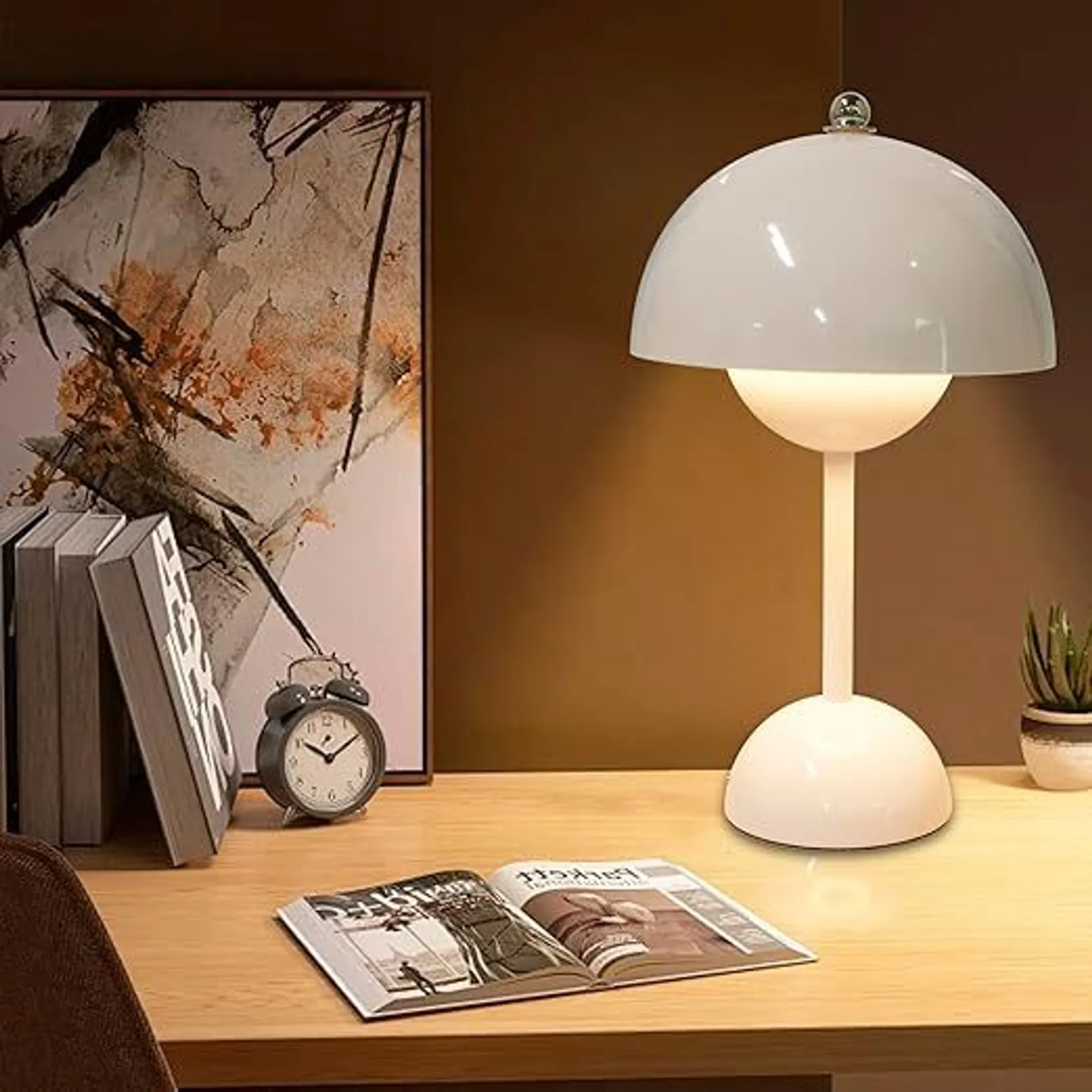 Ein weißer Pilz-Tischlampen-Schreibtisch mit Büchern, Uhr und Zeitschriften.