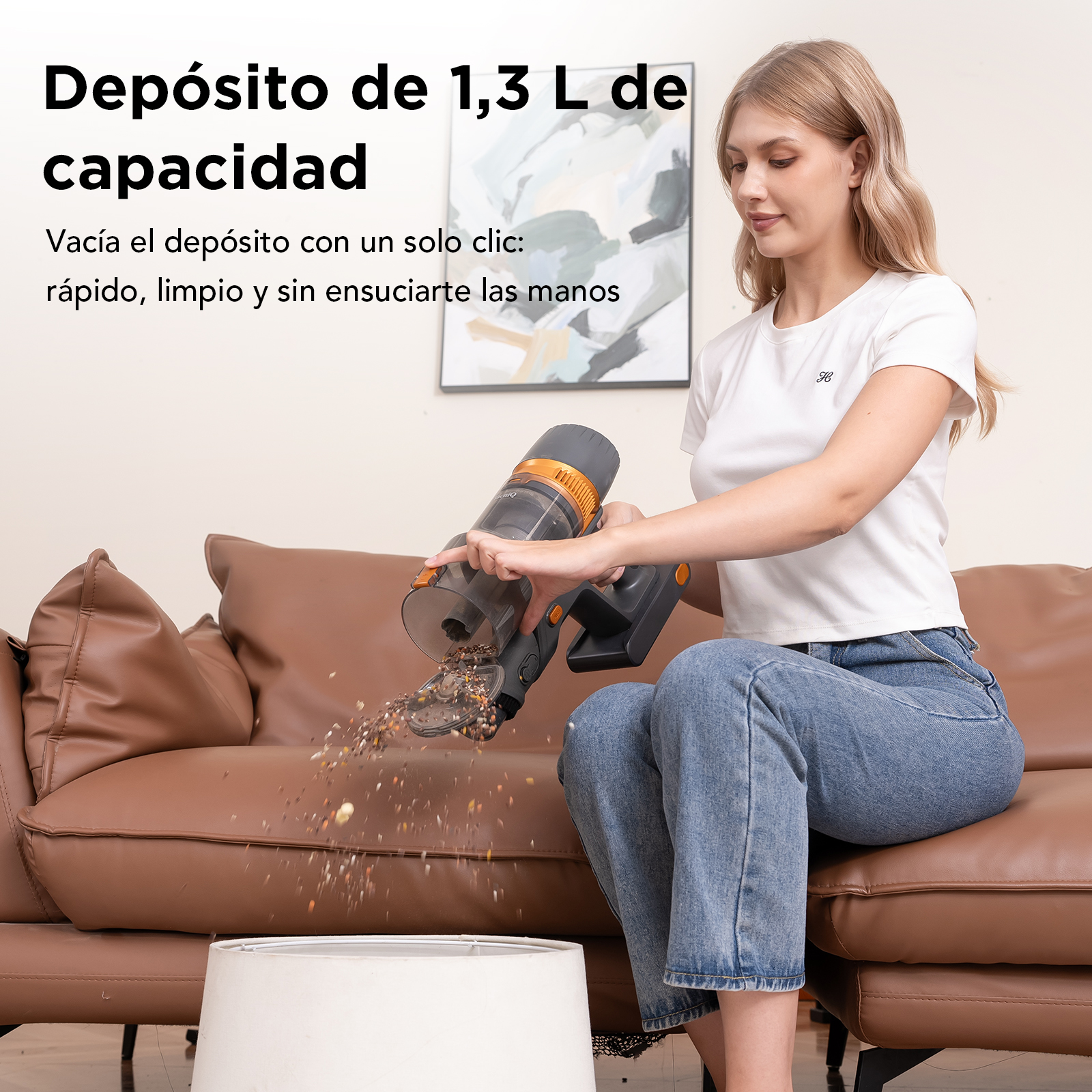 Una mujer vacía una aspiradora sobre un cubo sentada en un sofá marrón.