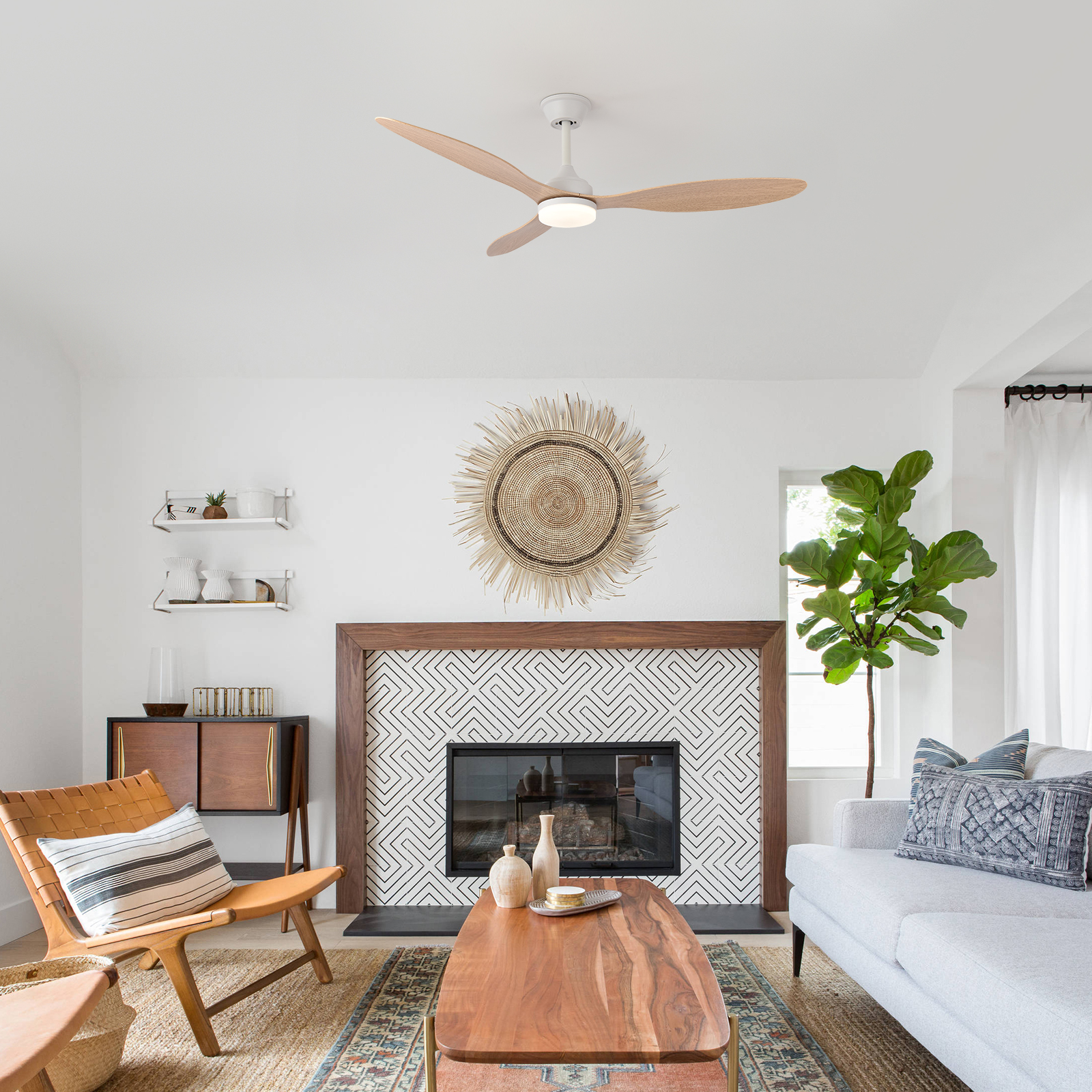 Sala de estar con chimenea, sillón de cuero, sofá, ventilador de techo y plantas.