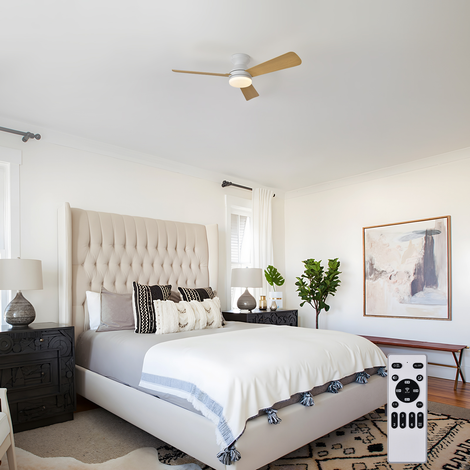 Un dormitorio con cama, mesitas de noche, ventilador de techo y cuadro.