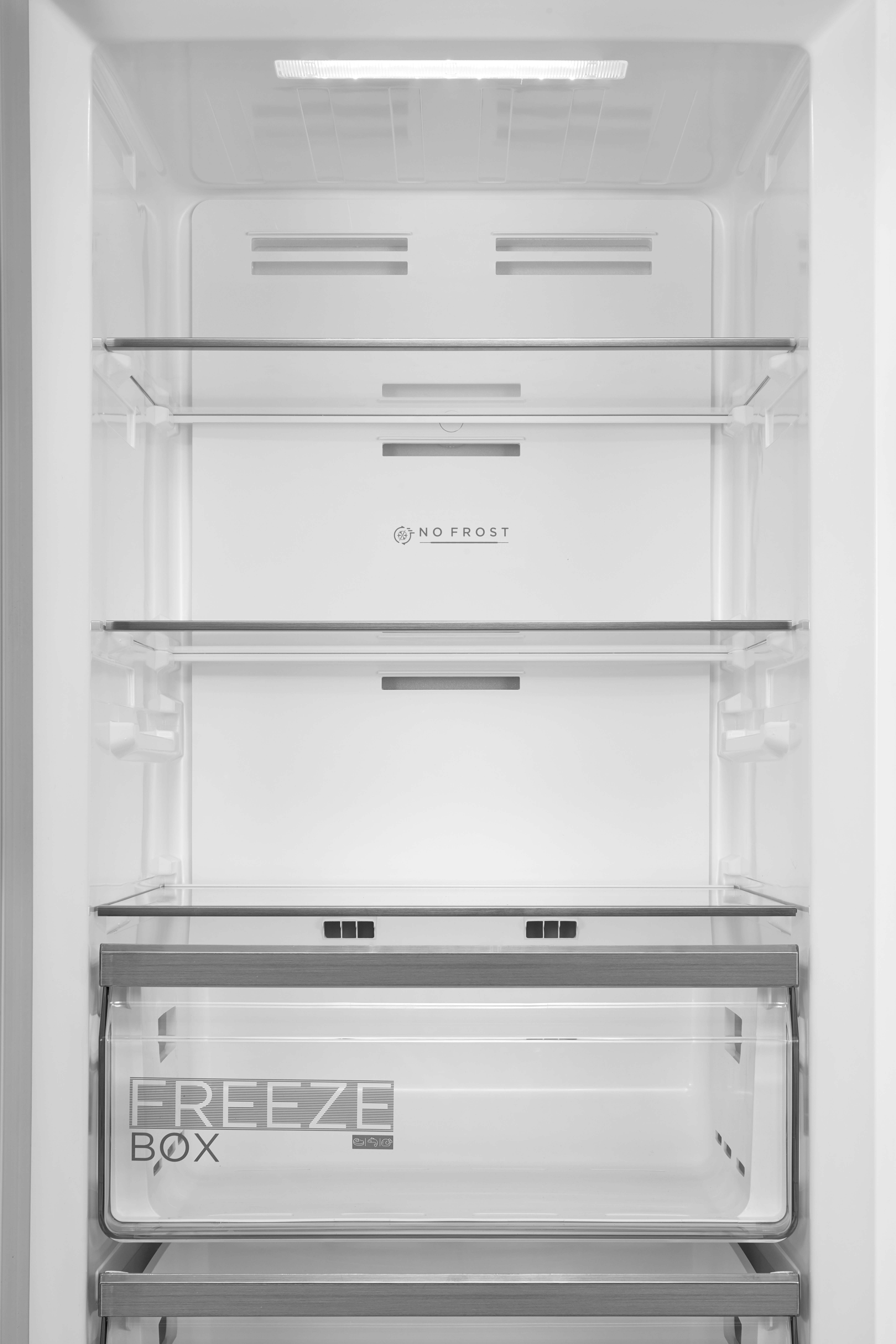 Leerer Kühlschrank mit Glasböden, Schublade und Beleuchtung.