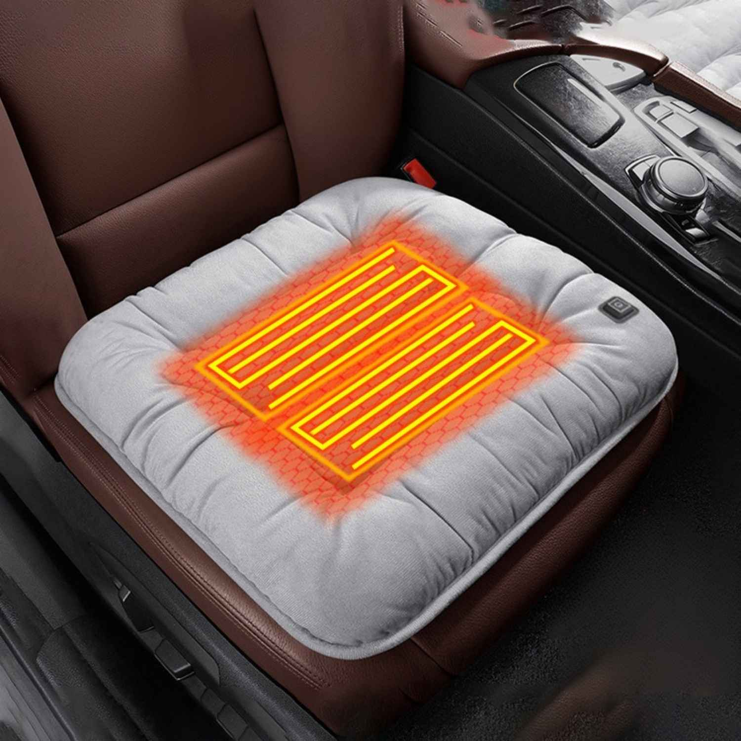 Ein graues beheiztes Autositzkissen mit leuchtend orangen Linien auf einem braunen Ledersitz.