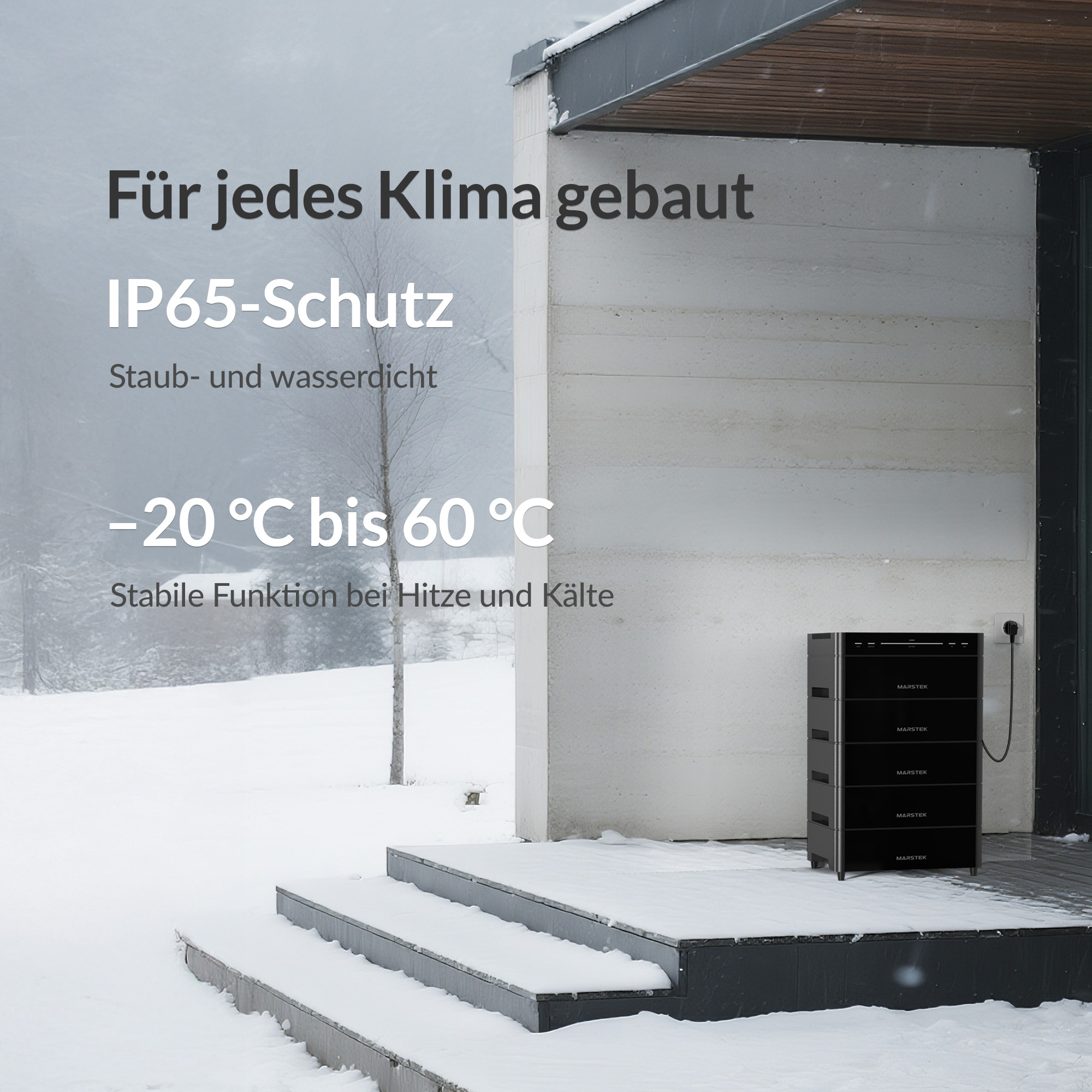 Schwarzer Energiespeicher mit mehreren Modulen vor einem Haus im Schnee.