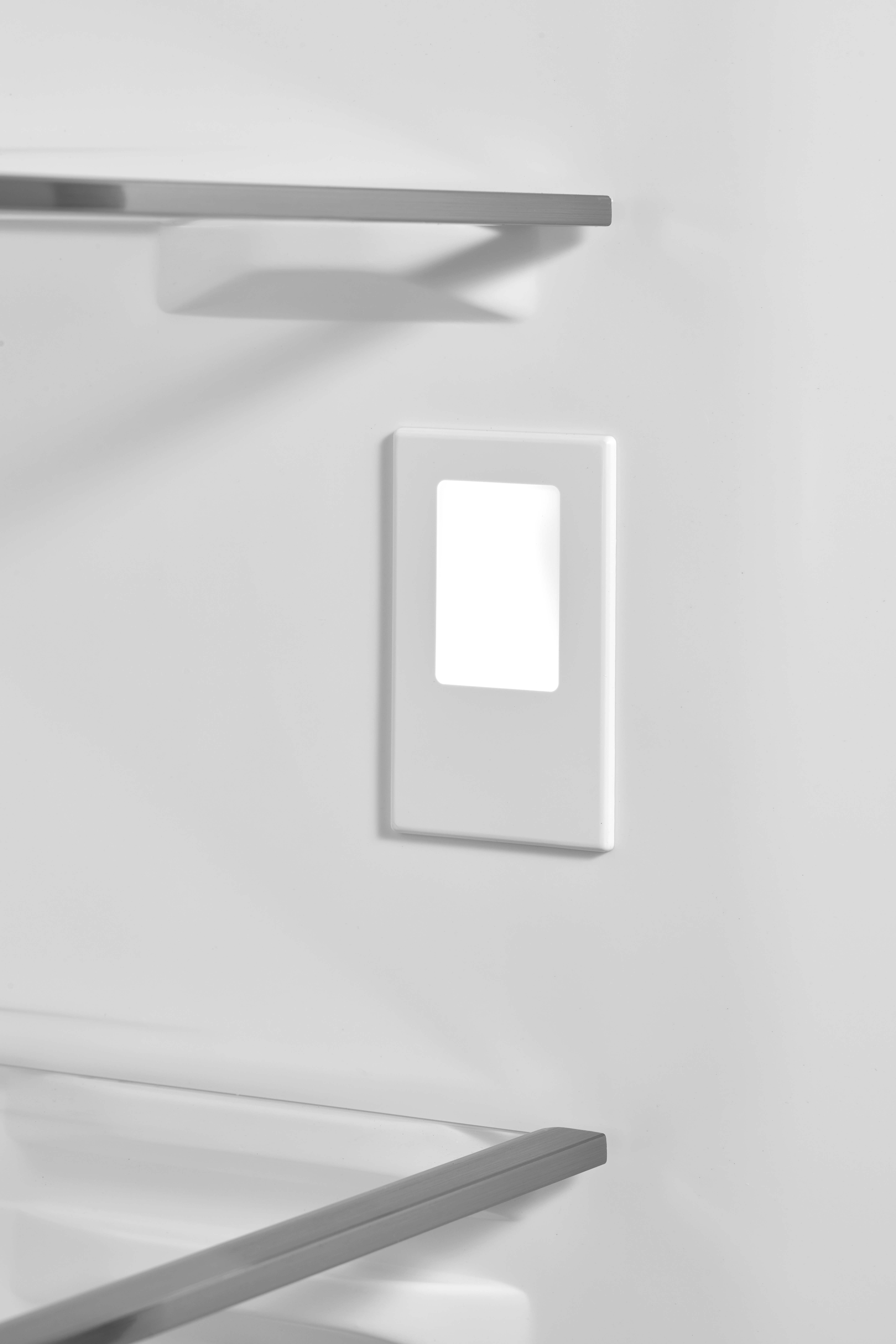 Ein weißer Lichtschalter mit rechteckiger Aussparung und silbernen Regalhaltern.