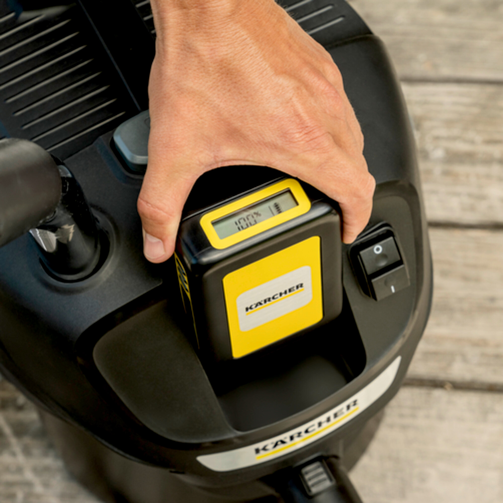 Main insère une batterie chargée à 100% dans l'appareil Kärcher.