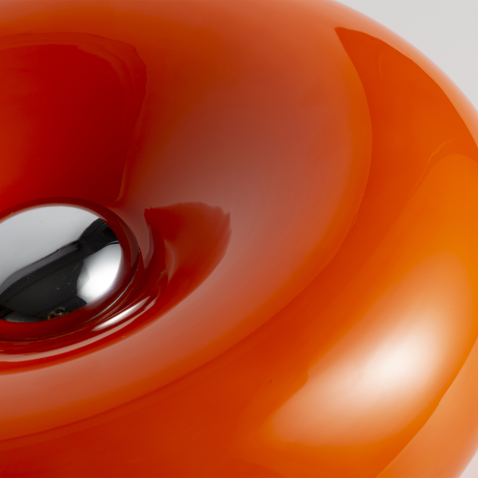 Primer plano de una lámpara naranja brillante con un inserto metálico.