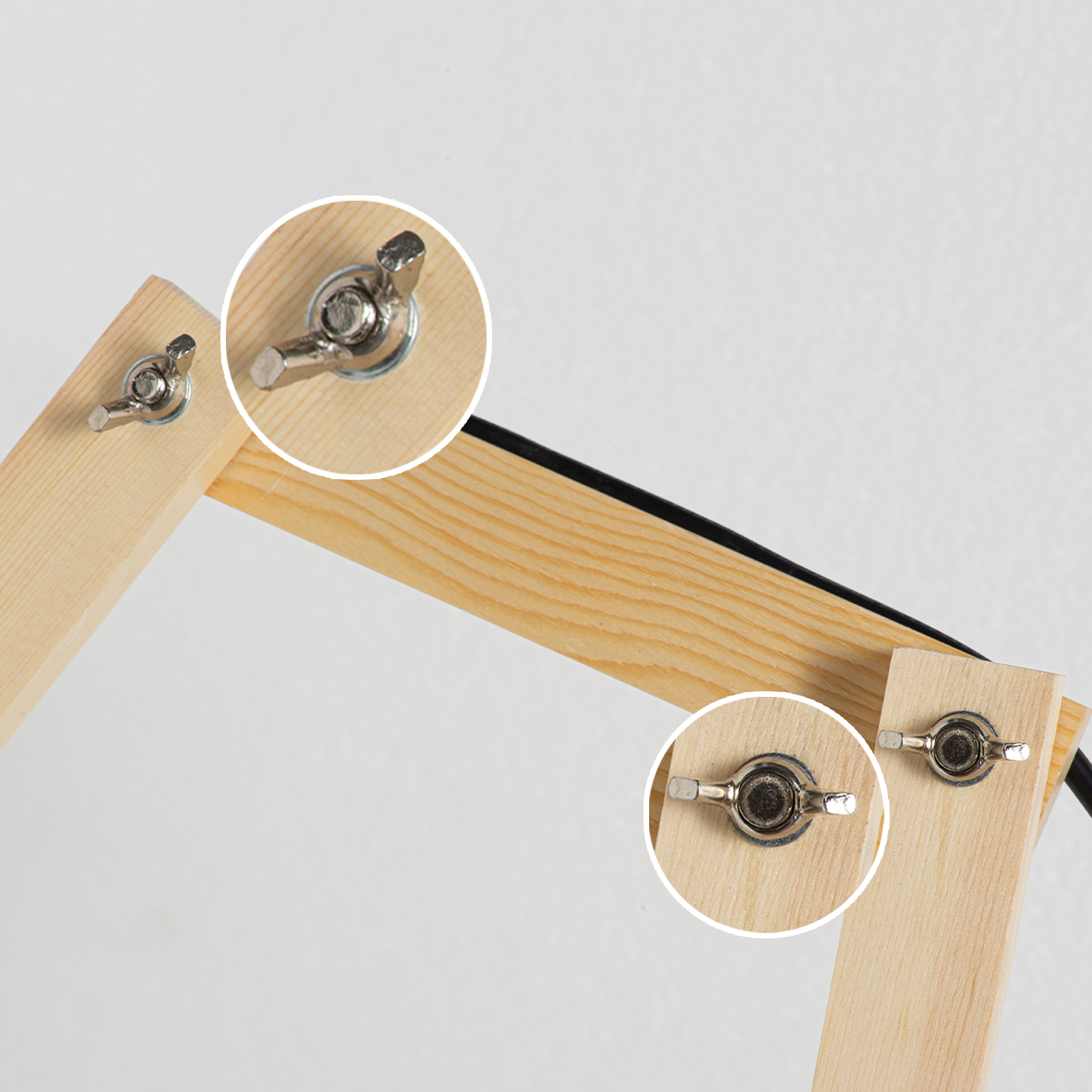 Accesorio de madera con tuercas de mariposa y cable negro.