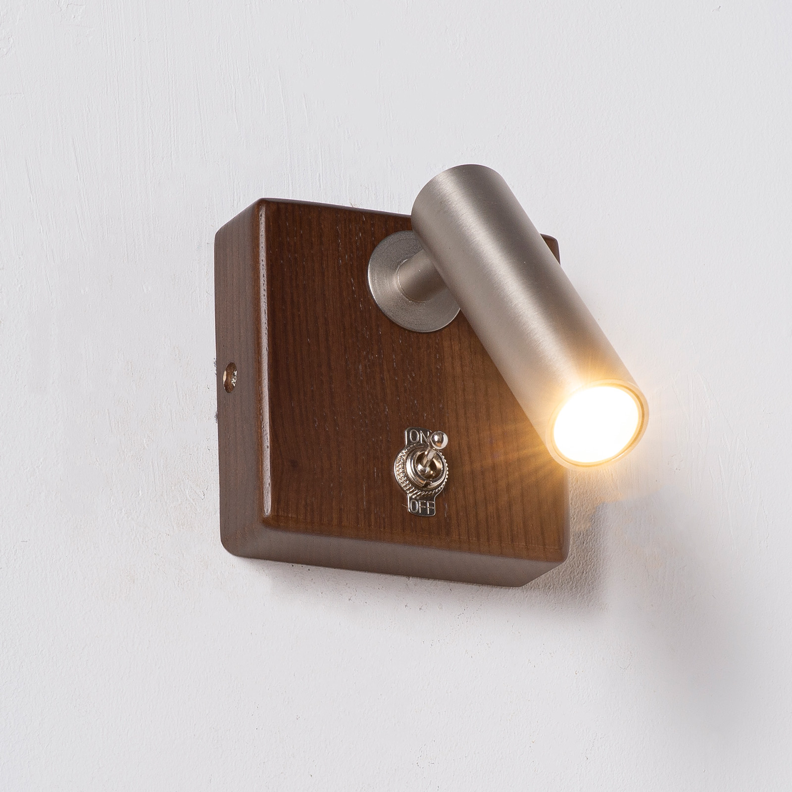 Un cubo de madera marrón con luz plateada y un interruptor.