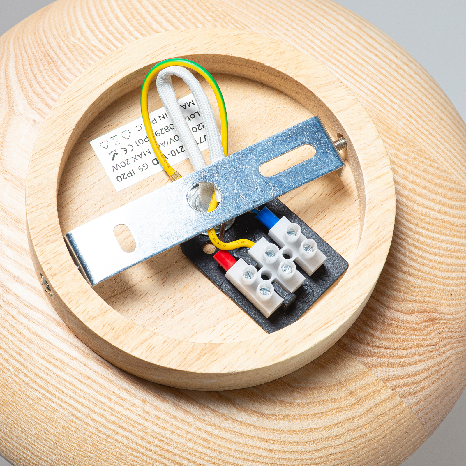 Carcasa de madera con cableado eléctrico, bloque de terminales y soporte metálico.