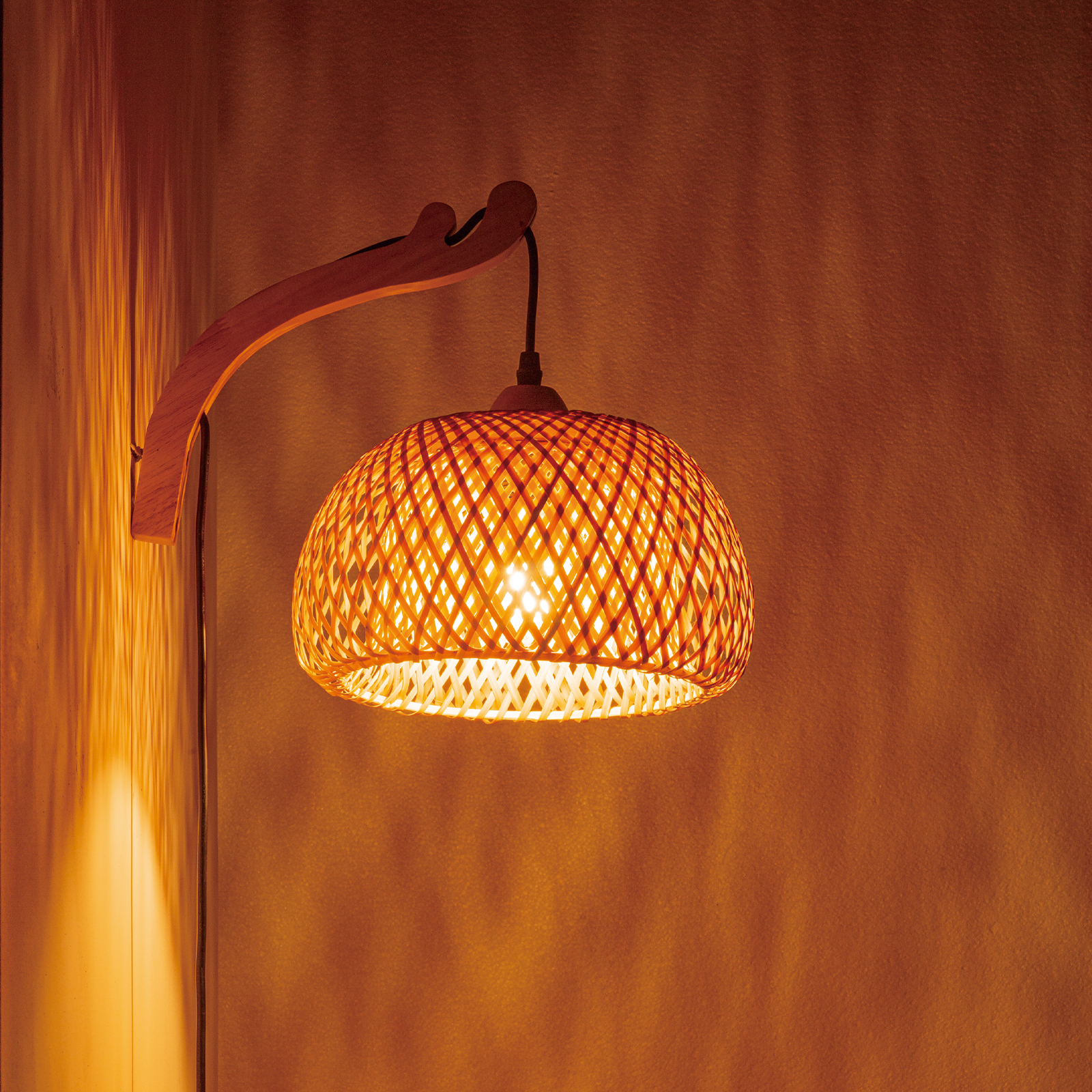 Una lámpara de pared de madera con pantalla tejida emite luz cálida.