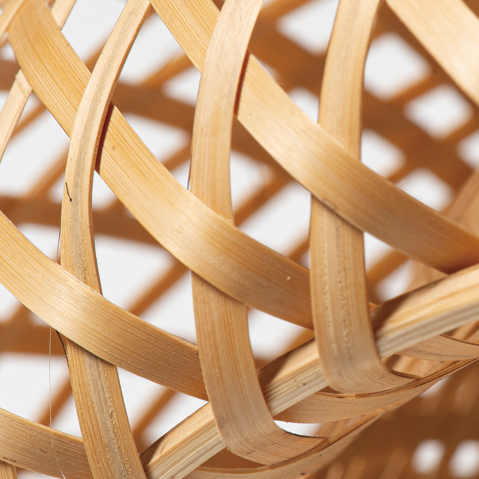 Primer plano de una cesta tejida de madera clara. Las tiras se superponen.