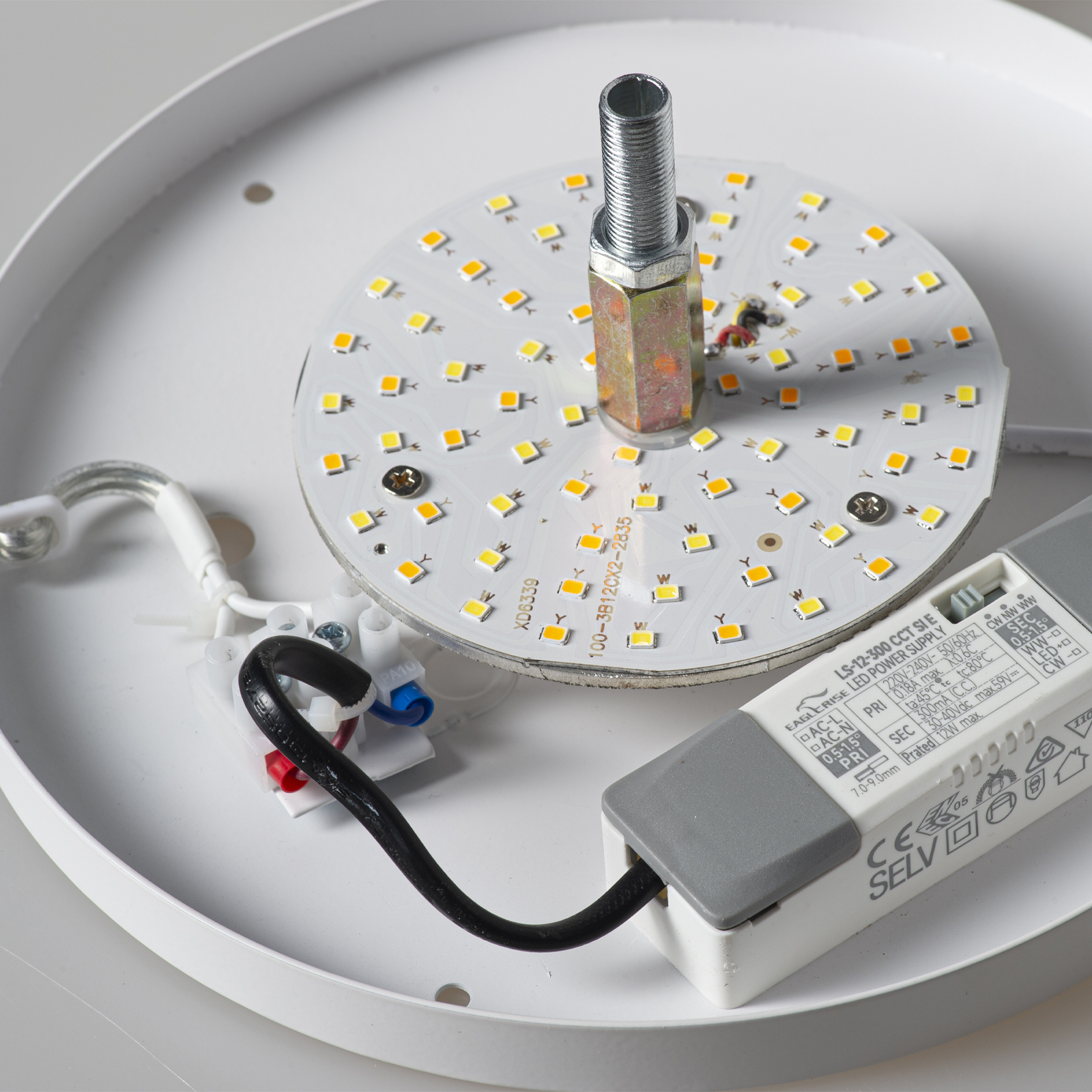 Base de lámpara blanca con placa LED, fuente de alimentación y cables.