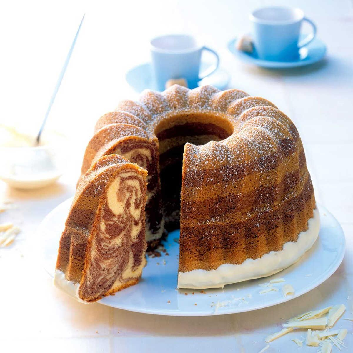 Marmor Gugelhupf mit weißer Glasur, bestäubt mit Puderzucker.