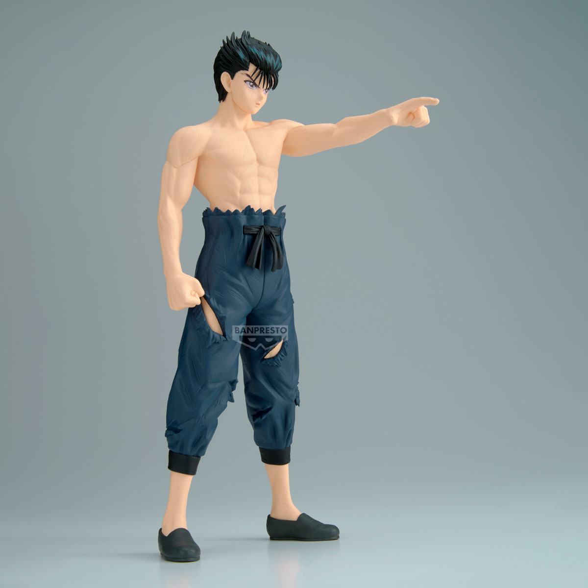 Figura anime senza maglietta con pantaloni blu strappati punta a destra.