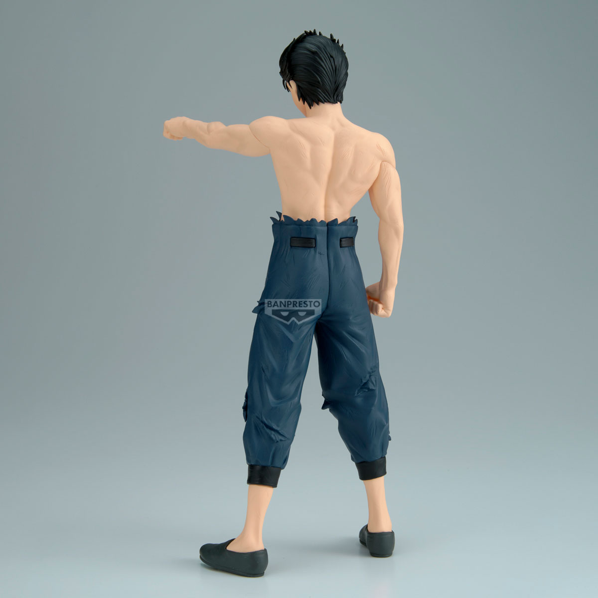 Una figura di uomo con capelli scuri che indossa pantaloni blu senza camicia.