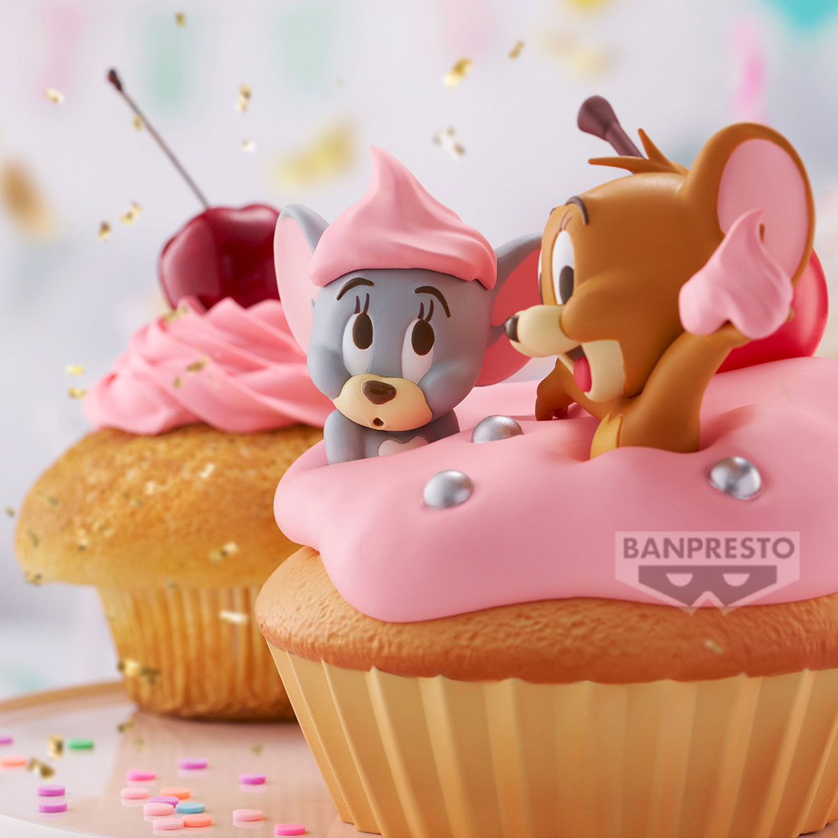 Figure di Tom e Jerry su cupcake rosa con ciliegie e codette.