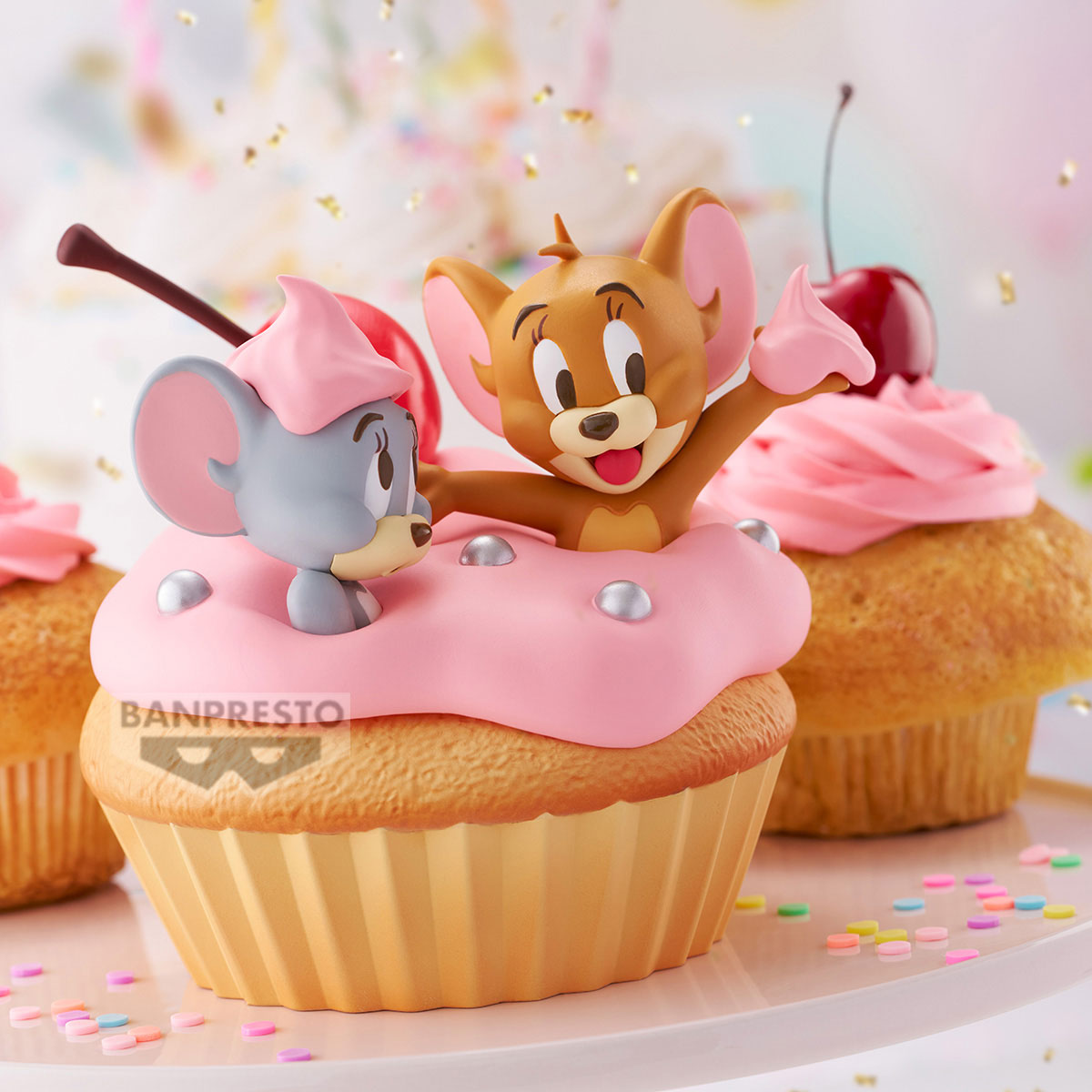 Figure di Tom e Jerry su cupcake rosa con ciliegie e codette.