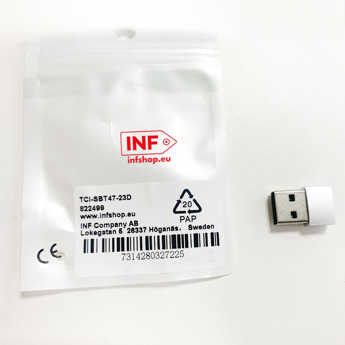 Pendrive obok zapakowanego przedmiotu z informacjami o produkcie.