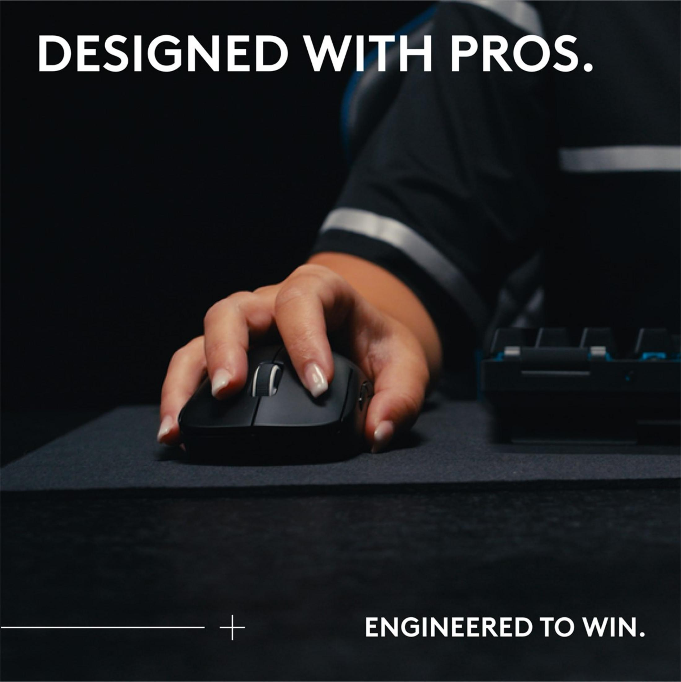 Una mano usa un mouse per computer nero su un tappetino nero, vicino a una tastiera.