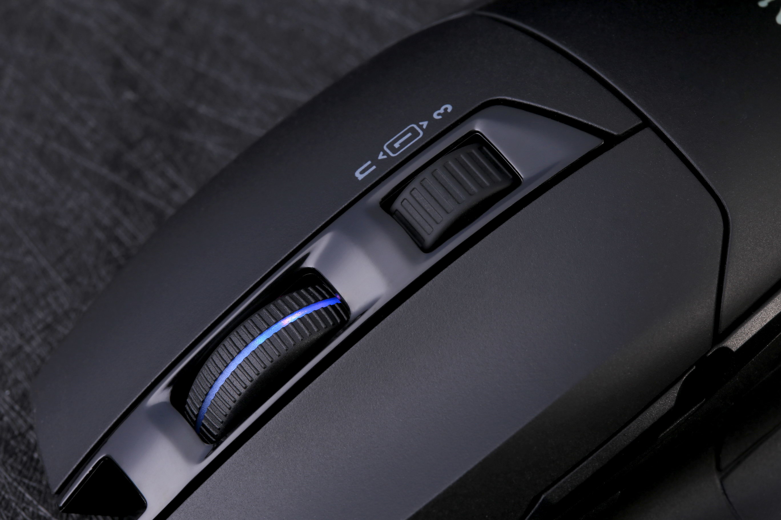 Primo piano di un mouse per computer nero con rotella di scorrimento e illuminazione blu.