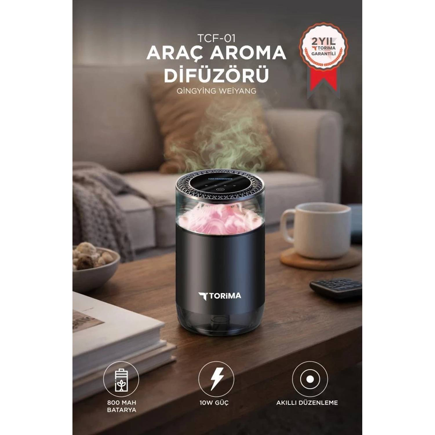 Ahşap masa üzerinde pembe çiçekler ve buharı olan siyah araç aroma difüzörü.