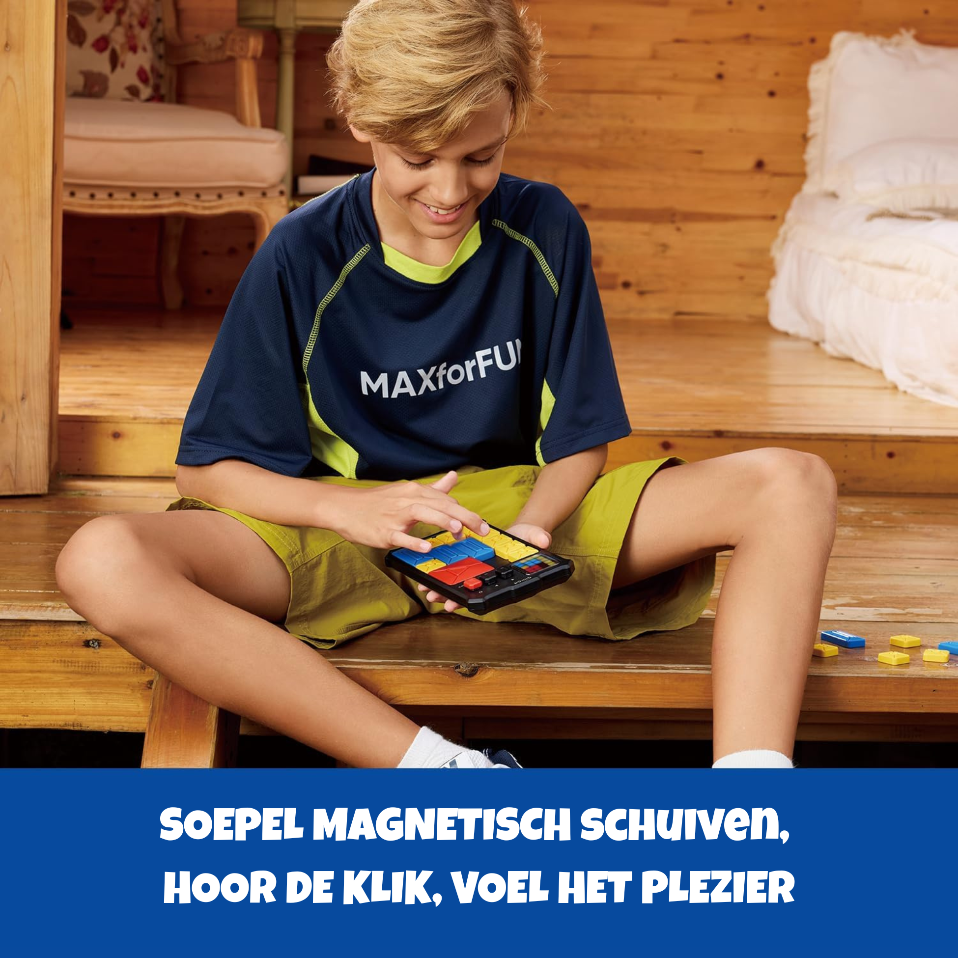 A boy plays a sliding puzzle on a wooden deck. He wears a blue shirt.