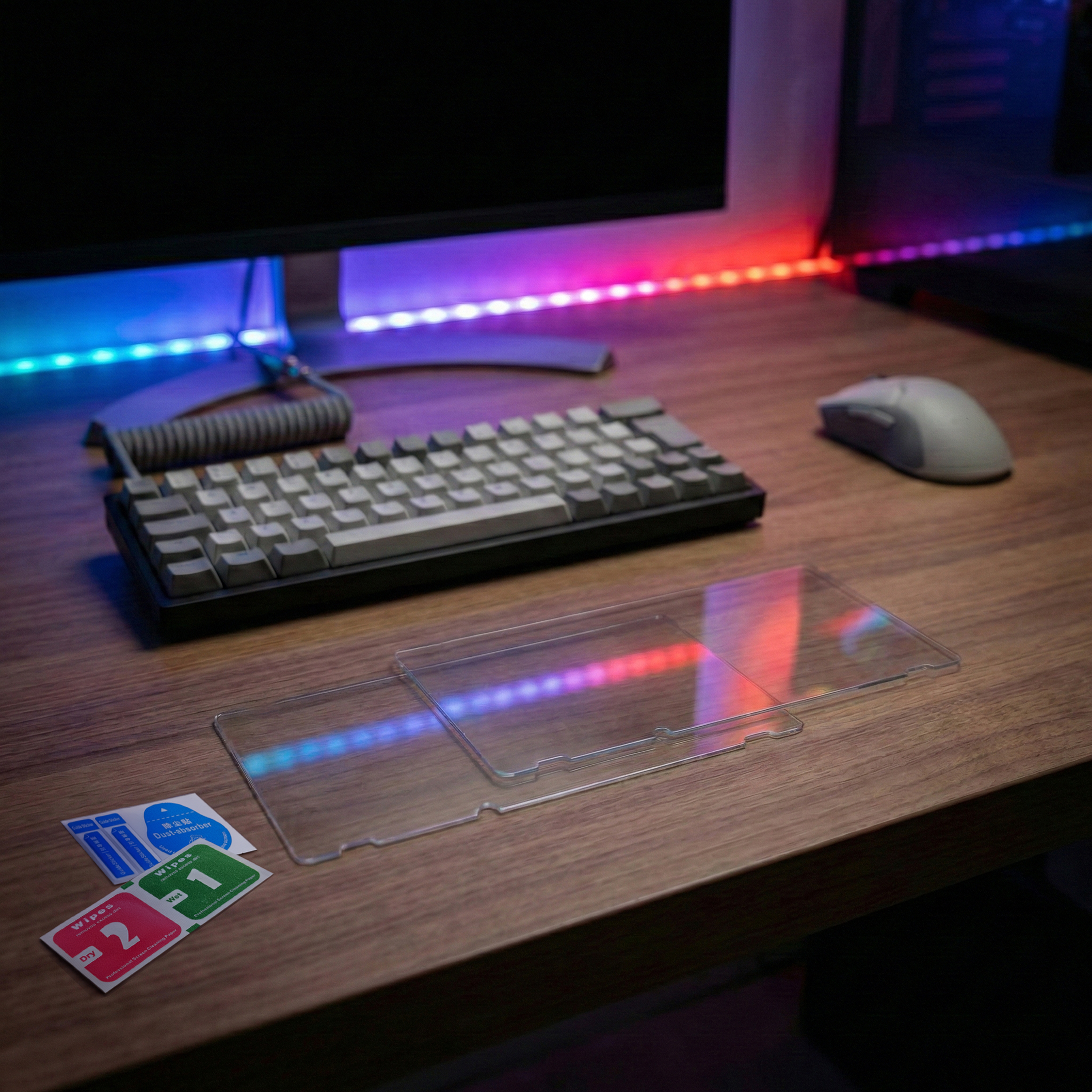 A keyboard, mouse, and screen protectors on a wooden desk. LED lights glow.