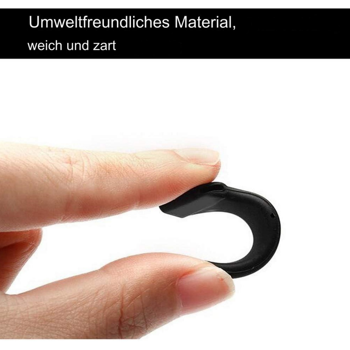 Eine Hand hält ein kleines, schwarzes, gebogenes Objekt aus flexiblem Material.