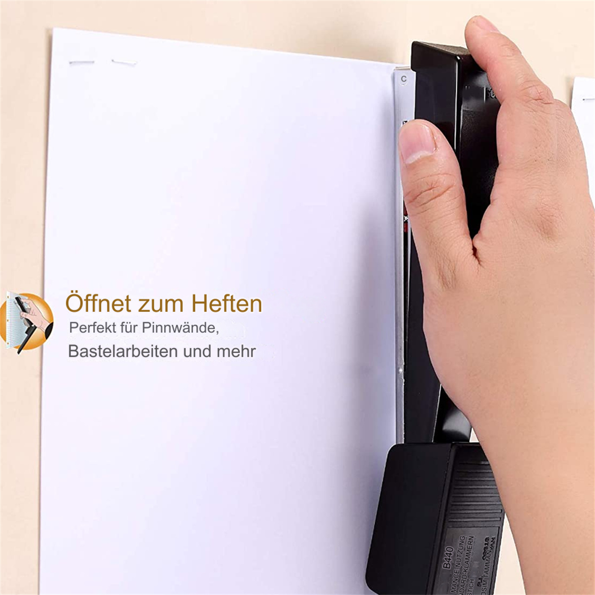 Eine Hand benutzt einen schwarzen Tacker, um Papier an einer Pinnwand zu befestigen.