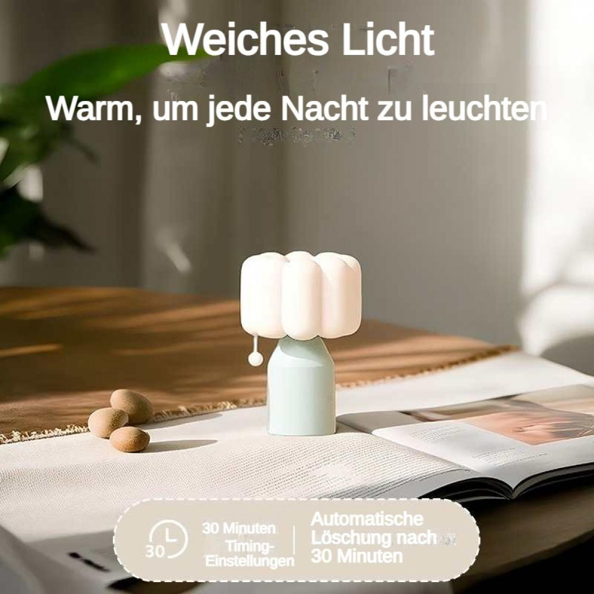 Eine kleine Lampe mit weißem Lampenschirm steht auf einem Tisch.