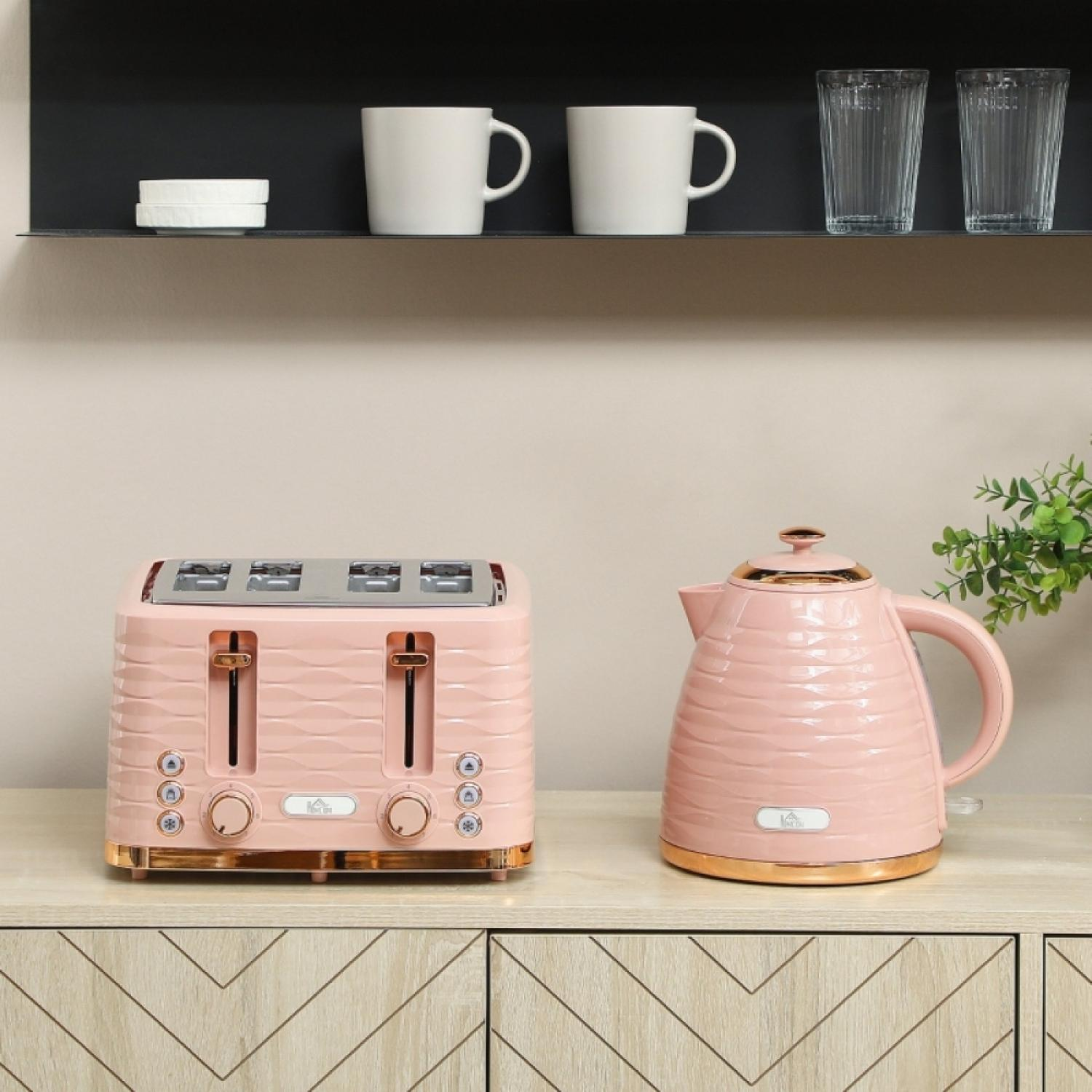 Ein rosafarbener Toaster und ein rosafarbener Wasserkocher stehen nebeneinander auf einem Holzschrank.