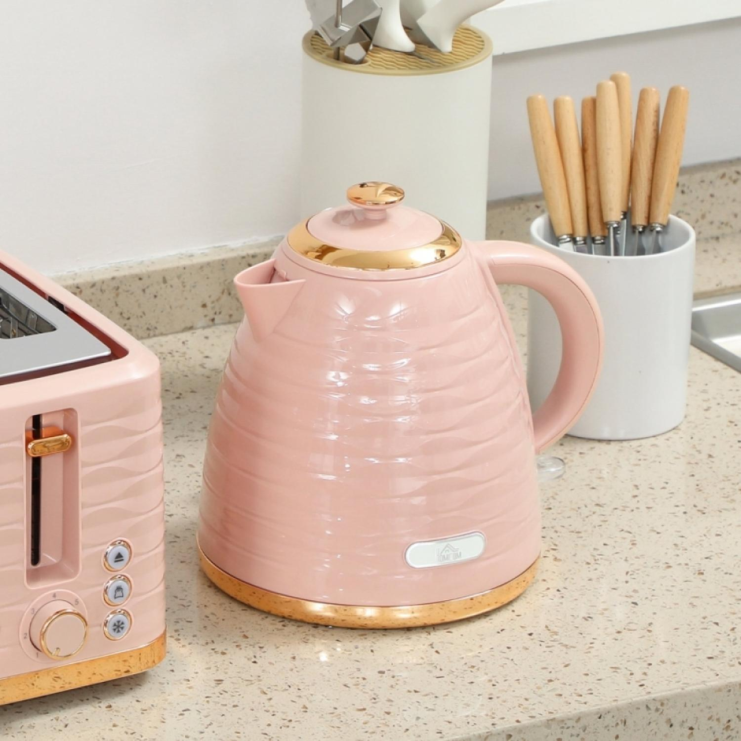 Ein rosa Wasserkocher und Toaster mit Golddetails auf einer Arbeitsplatte.