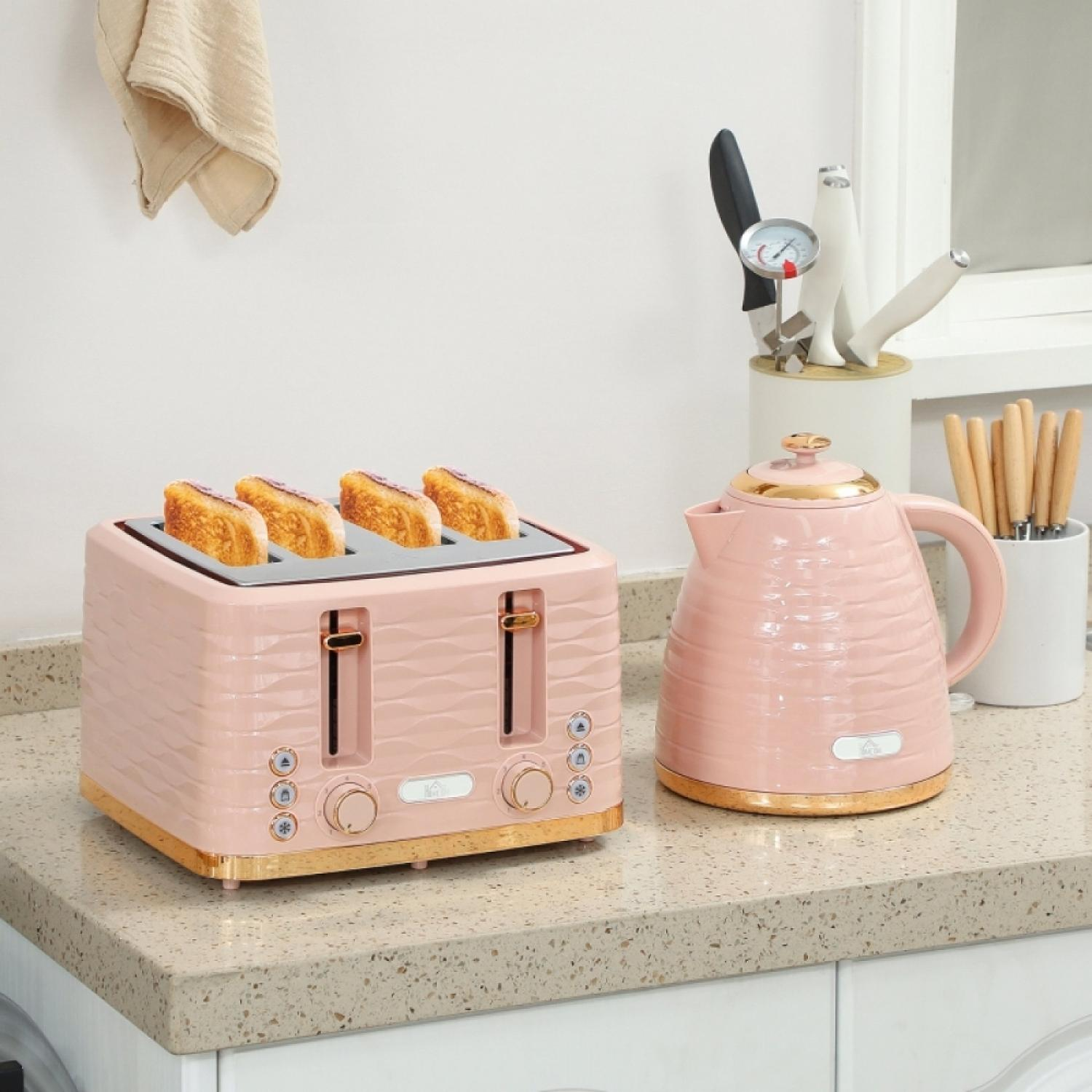 Ein rosa Toaster mit Toast und eine passende rosa Kanne auf einer Küchenarbeitsplatte.