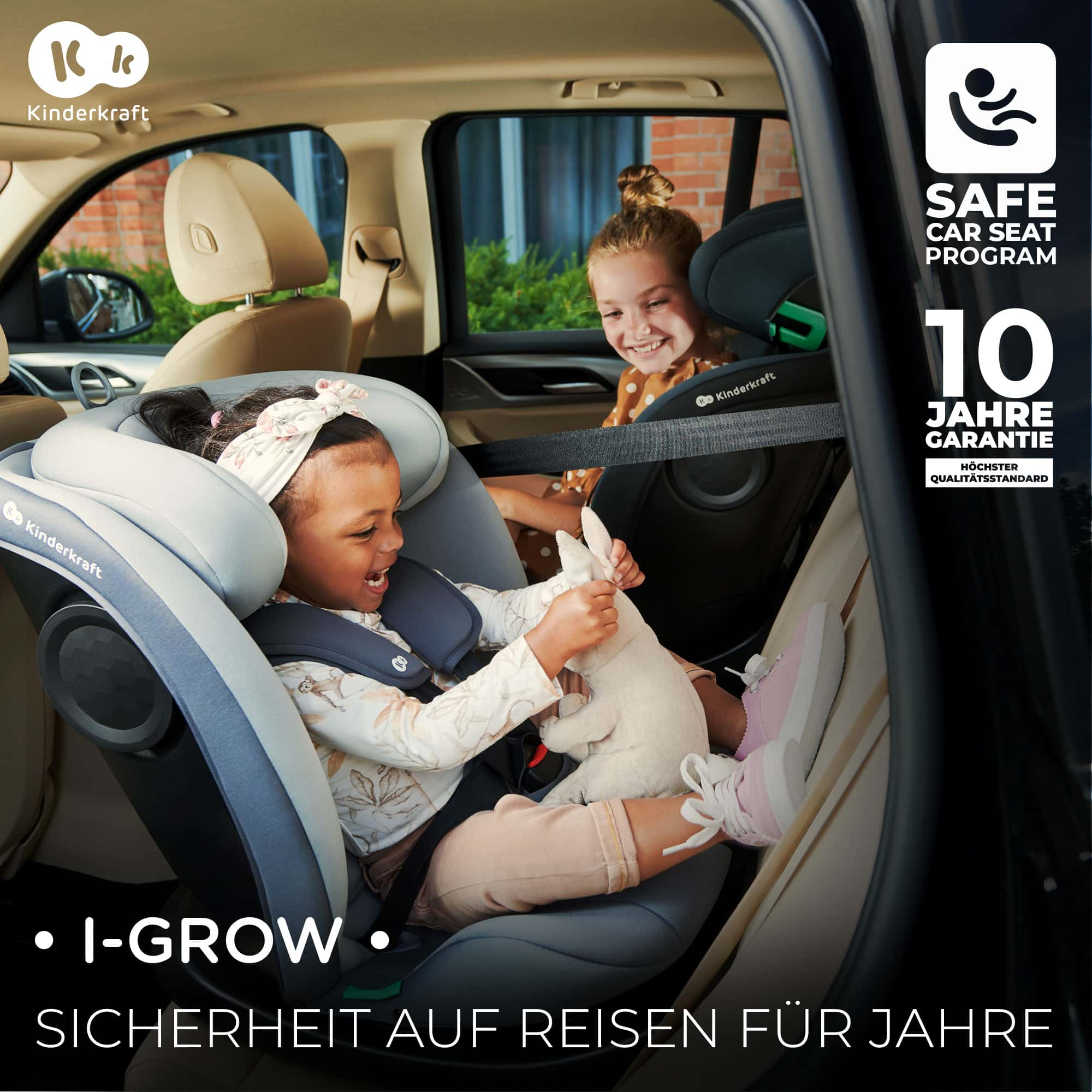 Zwei Mädchen in Kindersitzen im Auto spielen mit einem Stofftier.