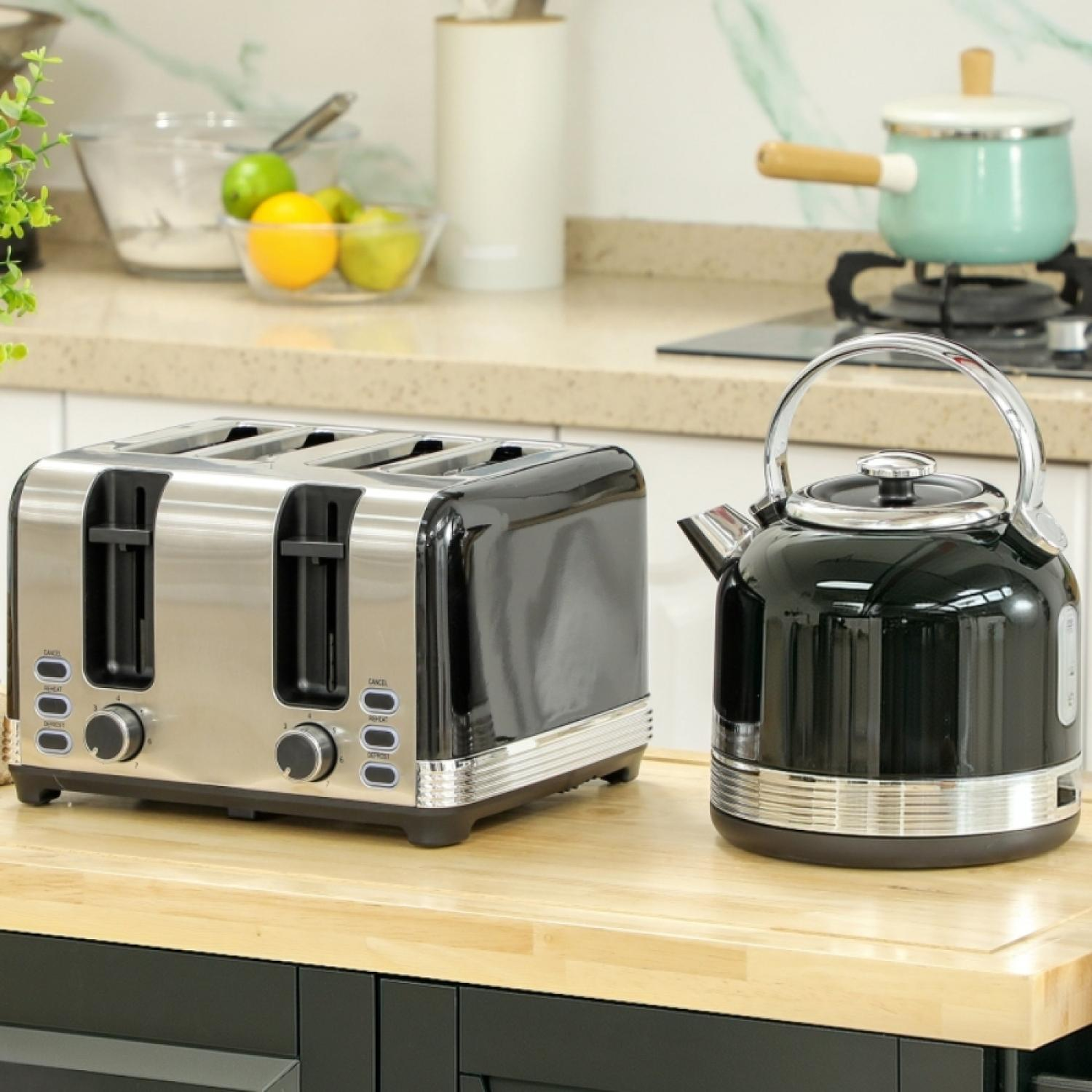 Ein silberner Toaster und ein schwarzer Wasserkocher stehen auf einer Holzoberfläche.