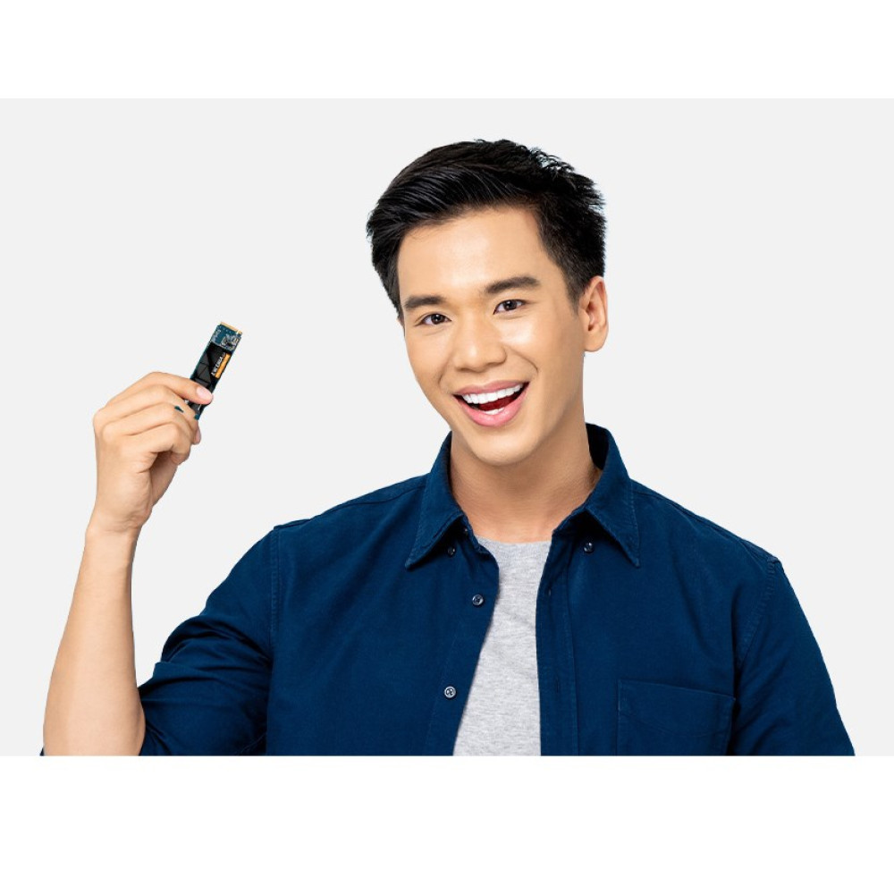 Mężczyzna w niebieskiej koszuli trzyma małą kartę pamięci.