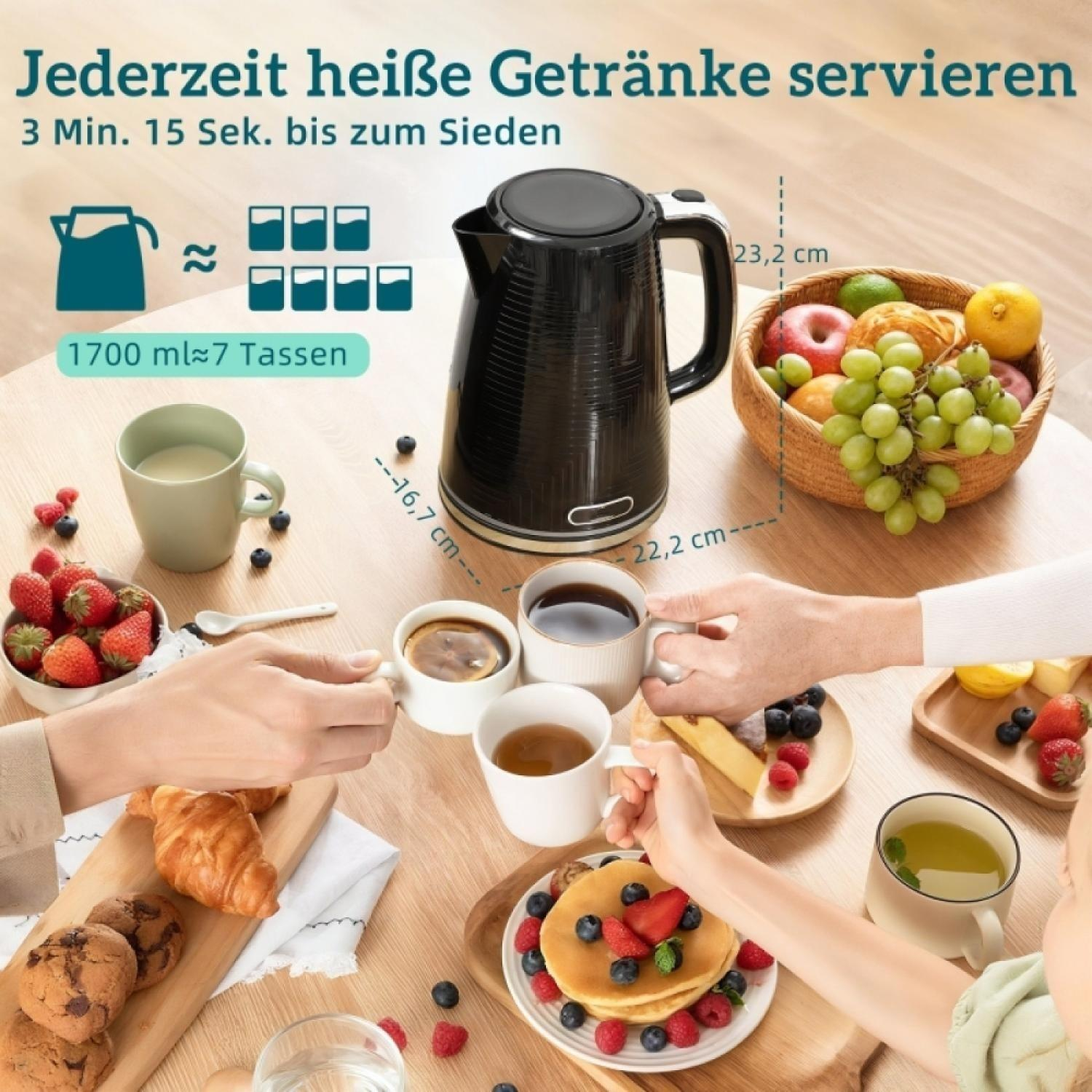 Ein schwarzer Wasserkocher steht auf einem Tisch mit Frühstück und Obst.