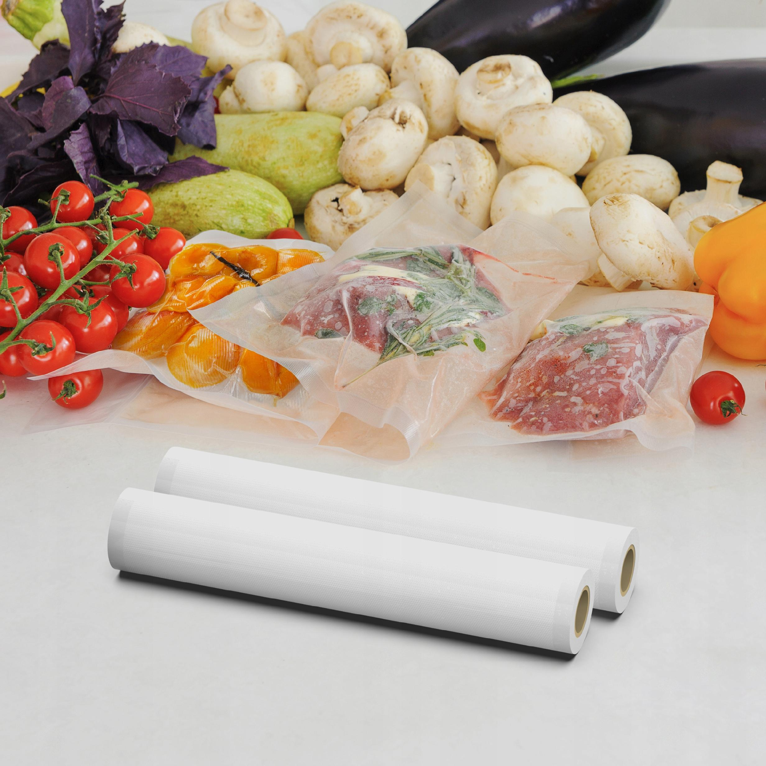 Kilka worków próżniowych z mięsem i warzywami, dwa rolki folii do pakowania próżniowego.