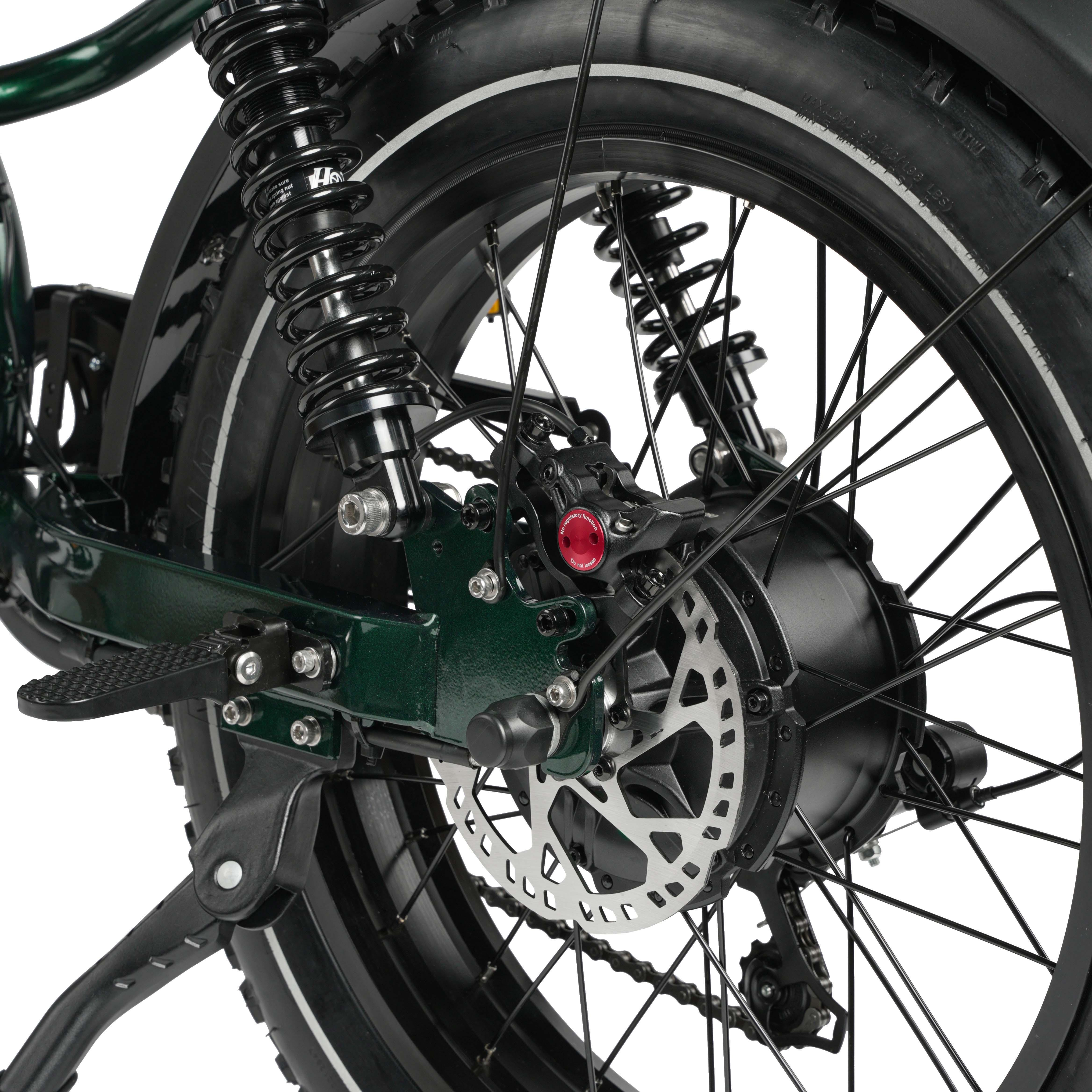 Widok z tyłu zielonego roweru z amortyzatorami, hamulcem tarczowym i łańcuchem.