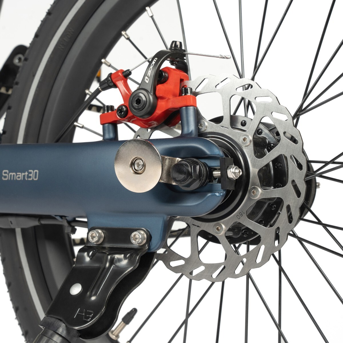 Zbliżenie tylnego koła niebieskiego roweru z hamulcem tarczowym i podpórką.