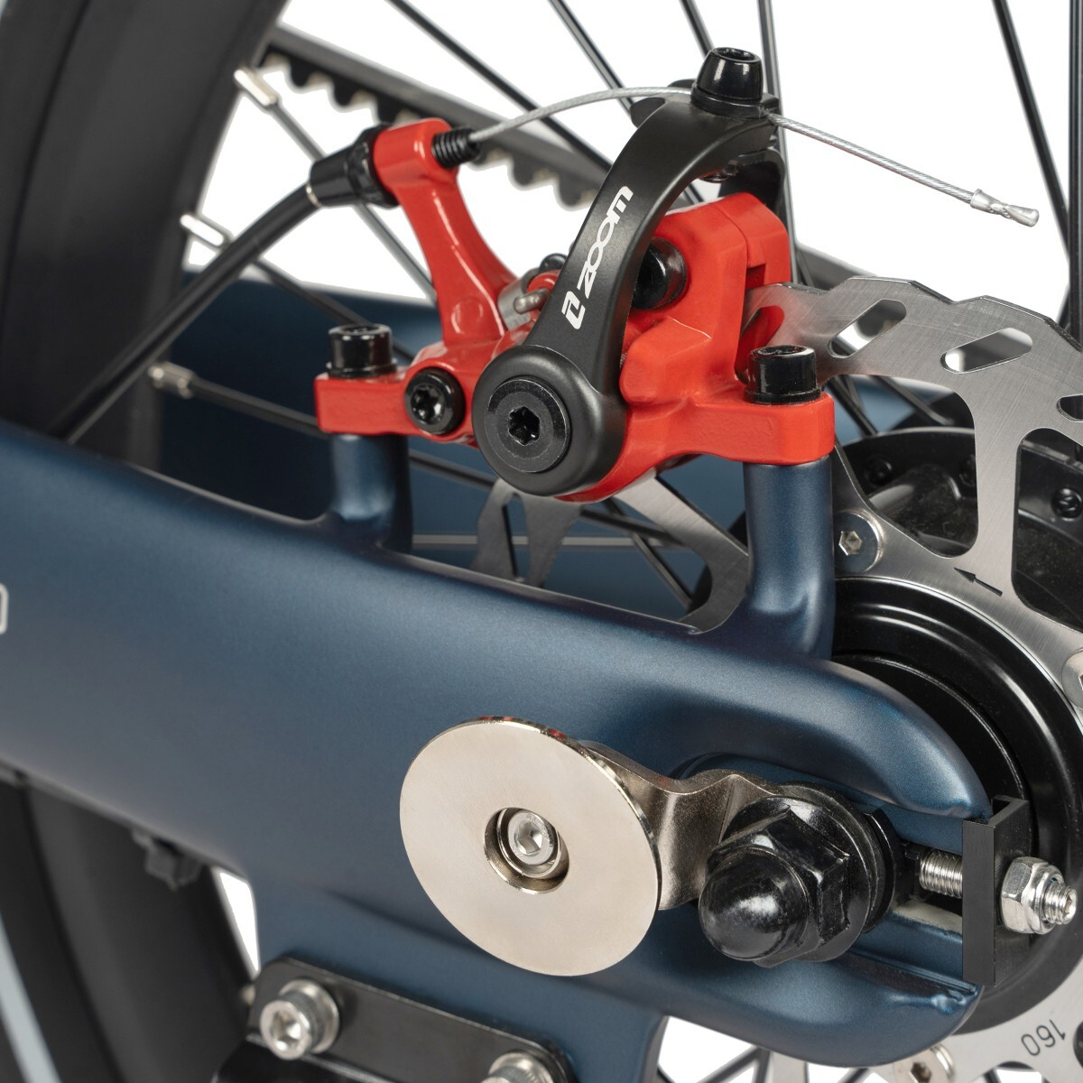 Zbliżenie tylnego hamulca tarczowego niebieskiego roweru z czerwonymi zaciskami.