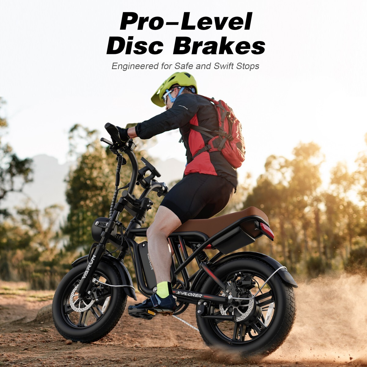 Mężczyzna jedzie czarnym e-bike z kaskiem w terenie, wzbijając kurz.