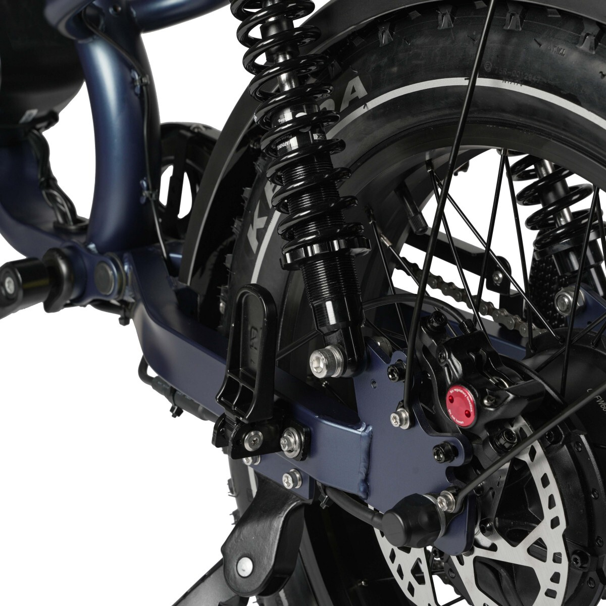 Nahaufnahme des Hinterrads eines dunkelblauen E-Bikes mit Federung, Bremsen und Kette.