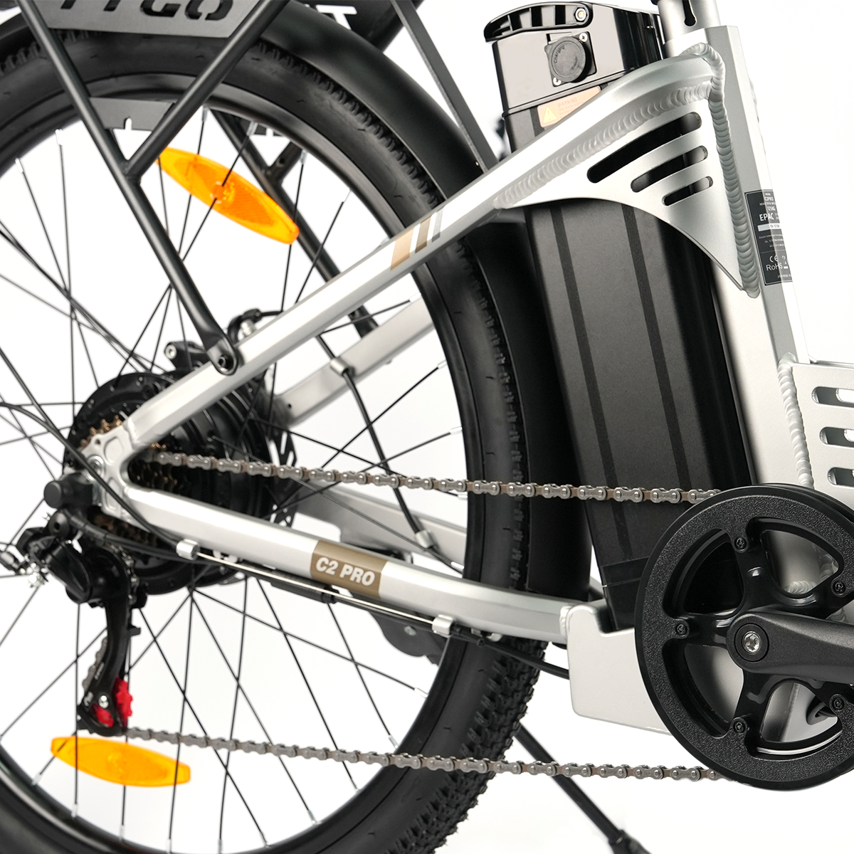 Zbliżenie na łańcuch, zębatkę i akumulator srebrnego roweru elektrycznego.