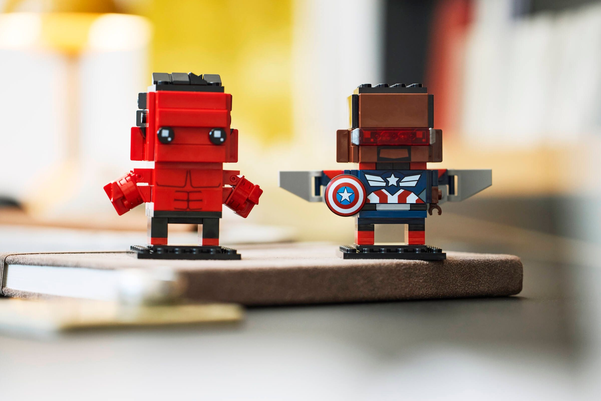 Yan yana duran iki Lego figürü, biri kırmızı, diğeri Kaptan Amerika tarzında.