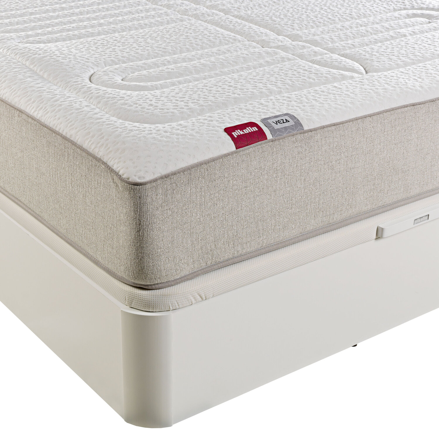 Un colchón blanco con tapa acolchada sobre una base de cama blanca.
